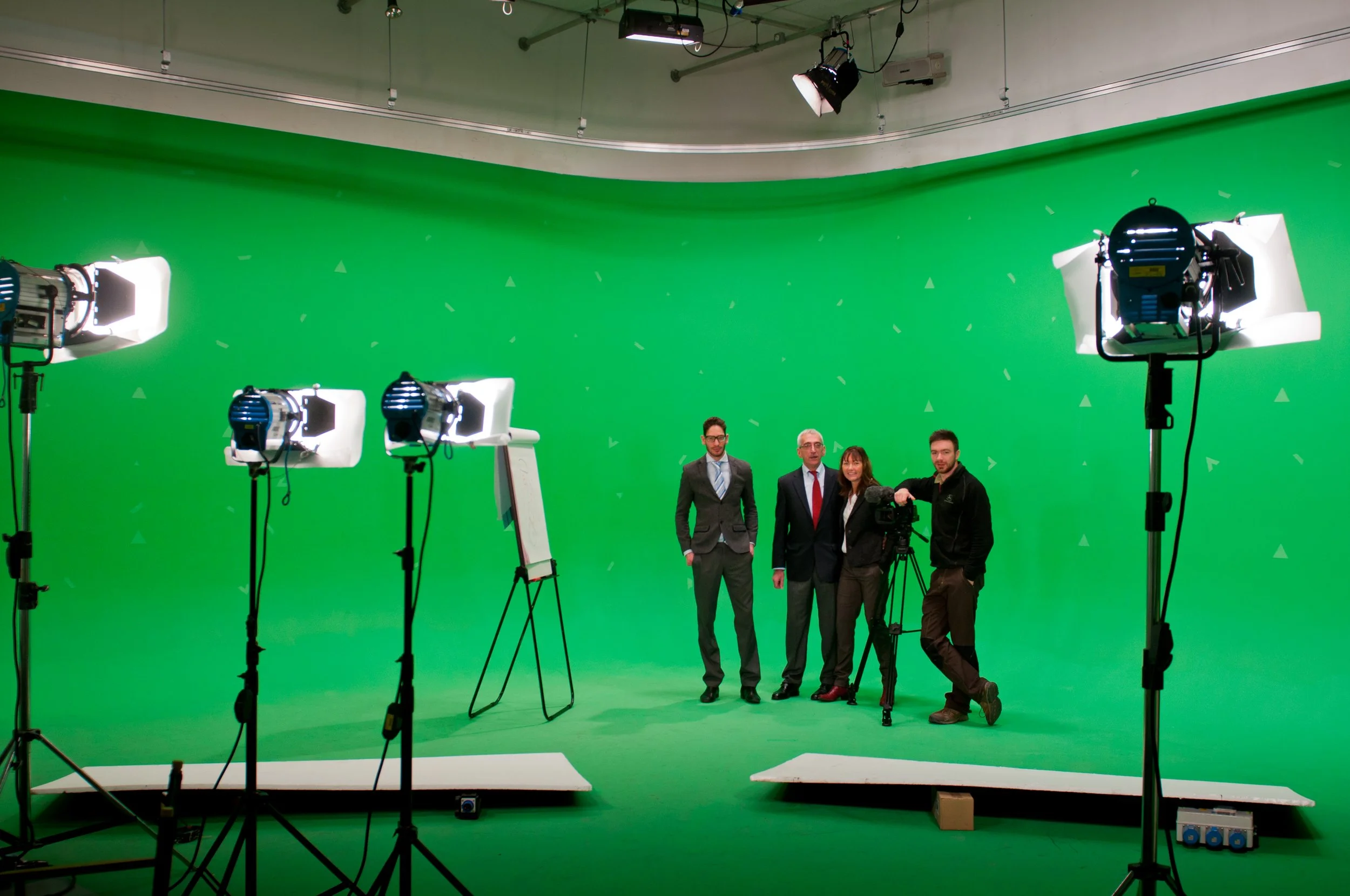 People in a green screen studio with lighting equipment