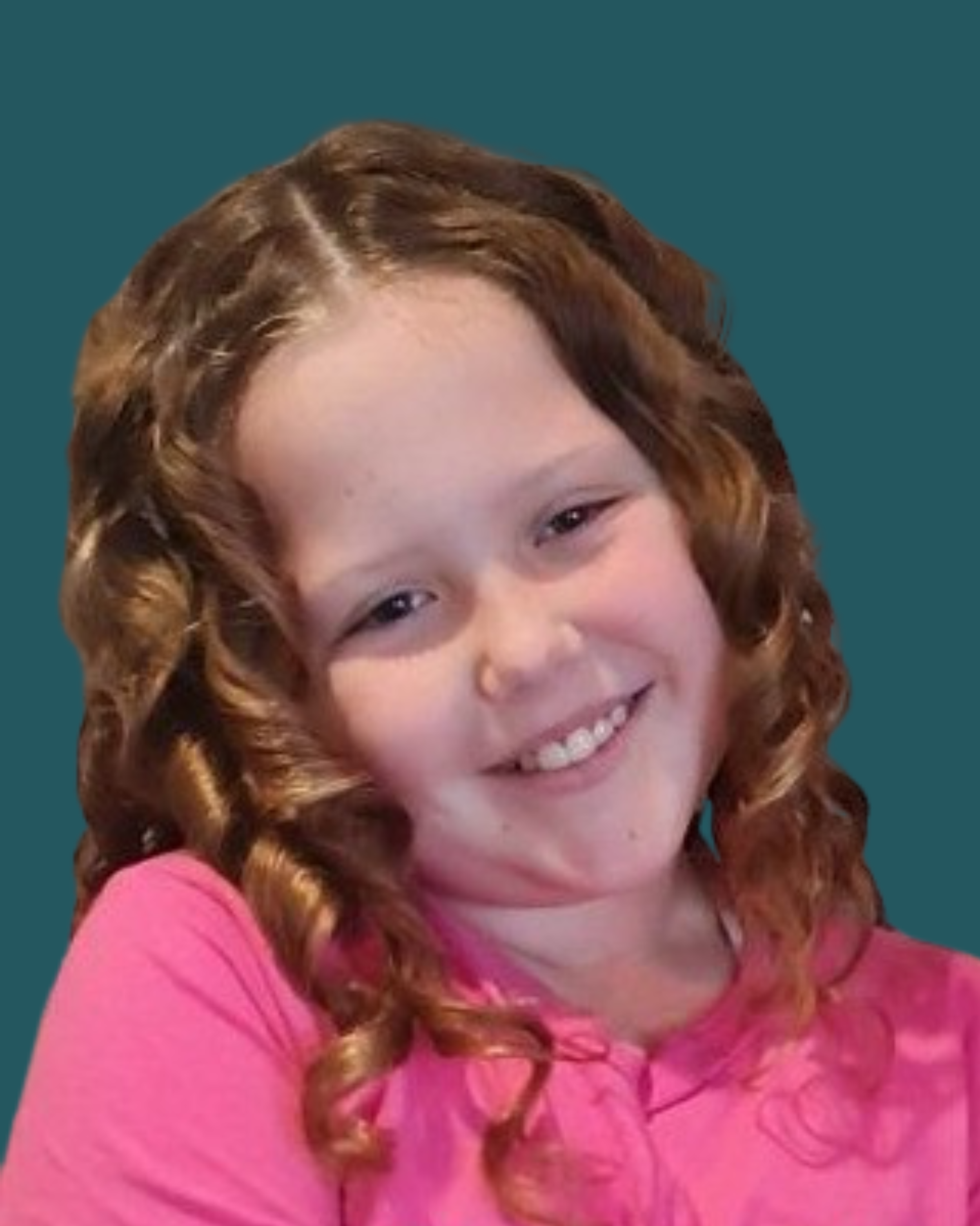 A young girl with curly red hair smiling, wearing a pink shirt, against a teal background.