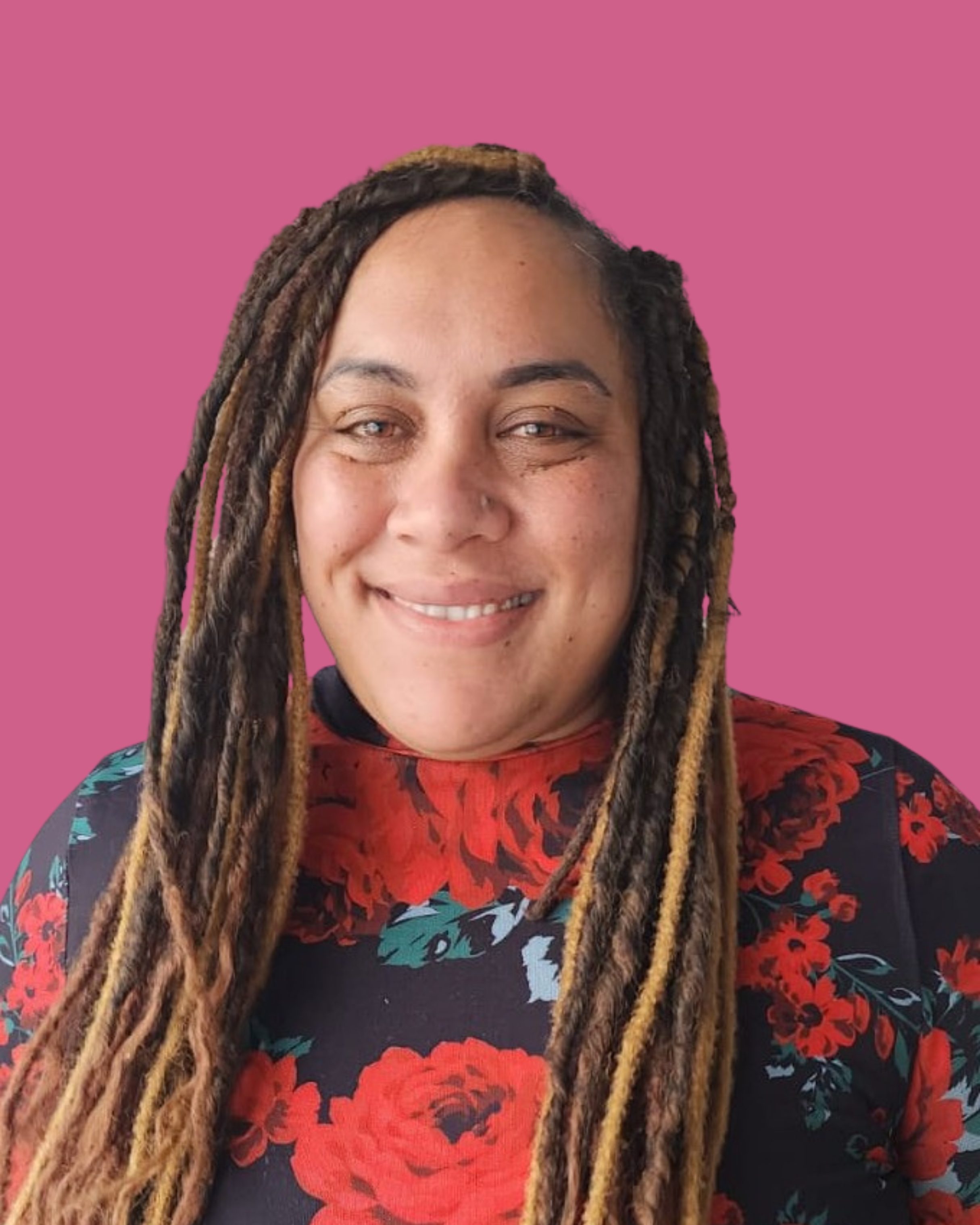 A woman with long dre garnered hair, smiling, wearing a floral dress with red roses on a dark background, and a pink background.