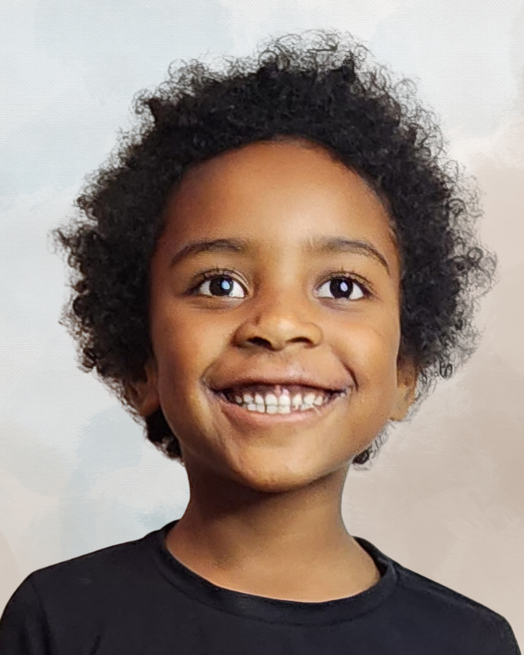 A young child with curly hair, smiling, wearing a black shirt, against a light background.