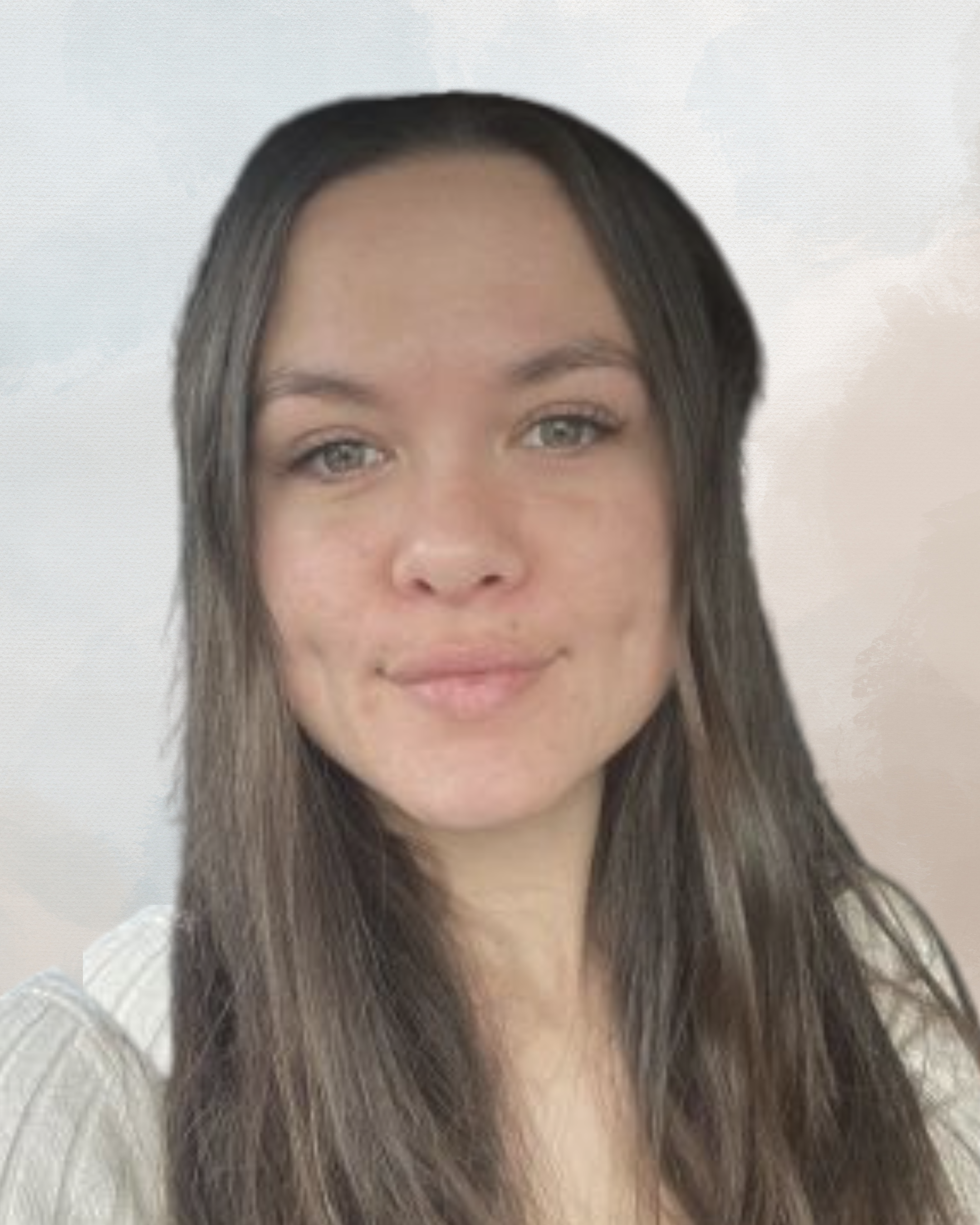 A young woman with long, dark brown hair and light green eyes, wearing a white top, smiling softly, with a blurred light-colored background.