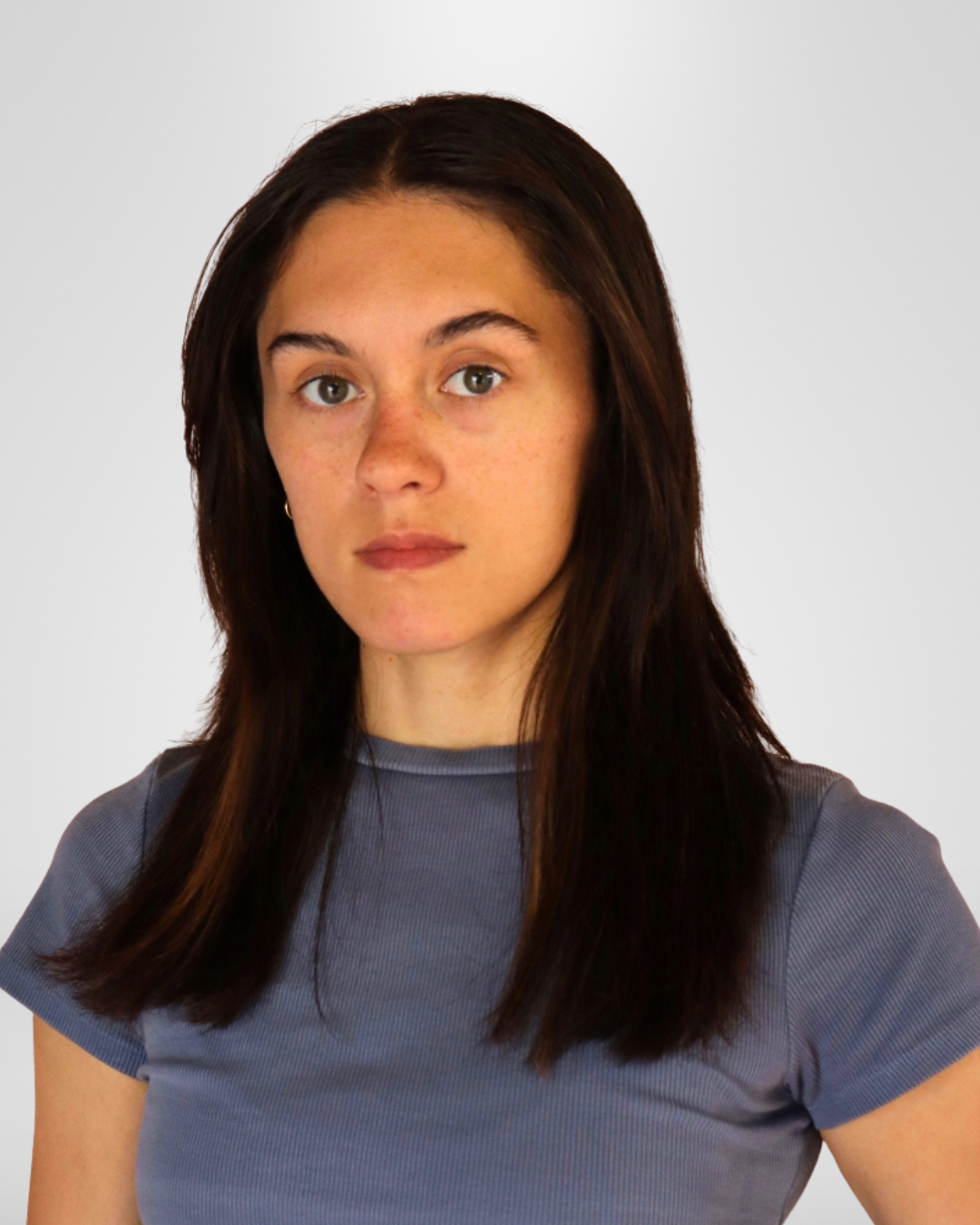 A young woman with long dark hair wearing a gray t-shirt against a plain white background.