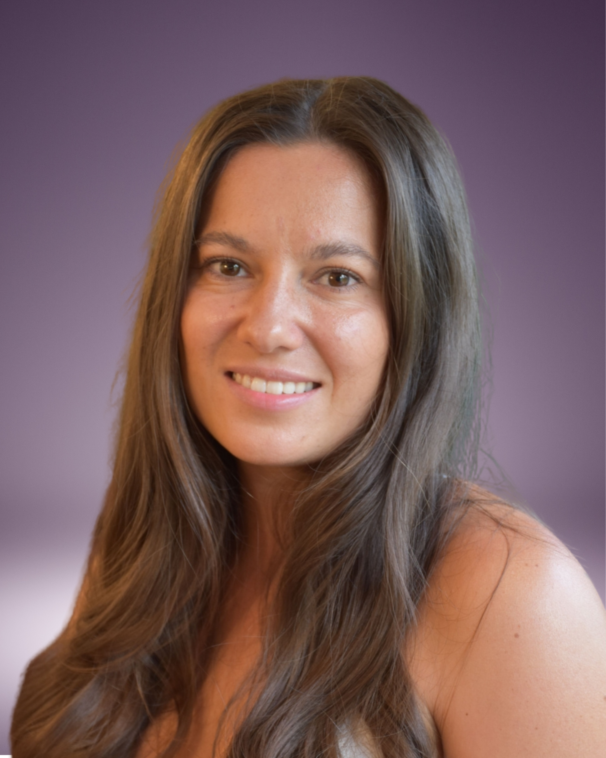 A woman with long brown hair smiling, against a purple gradient background.