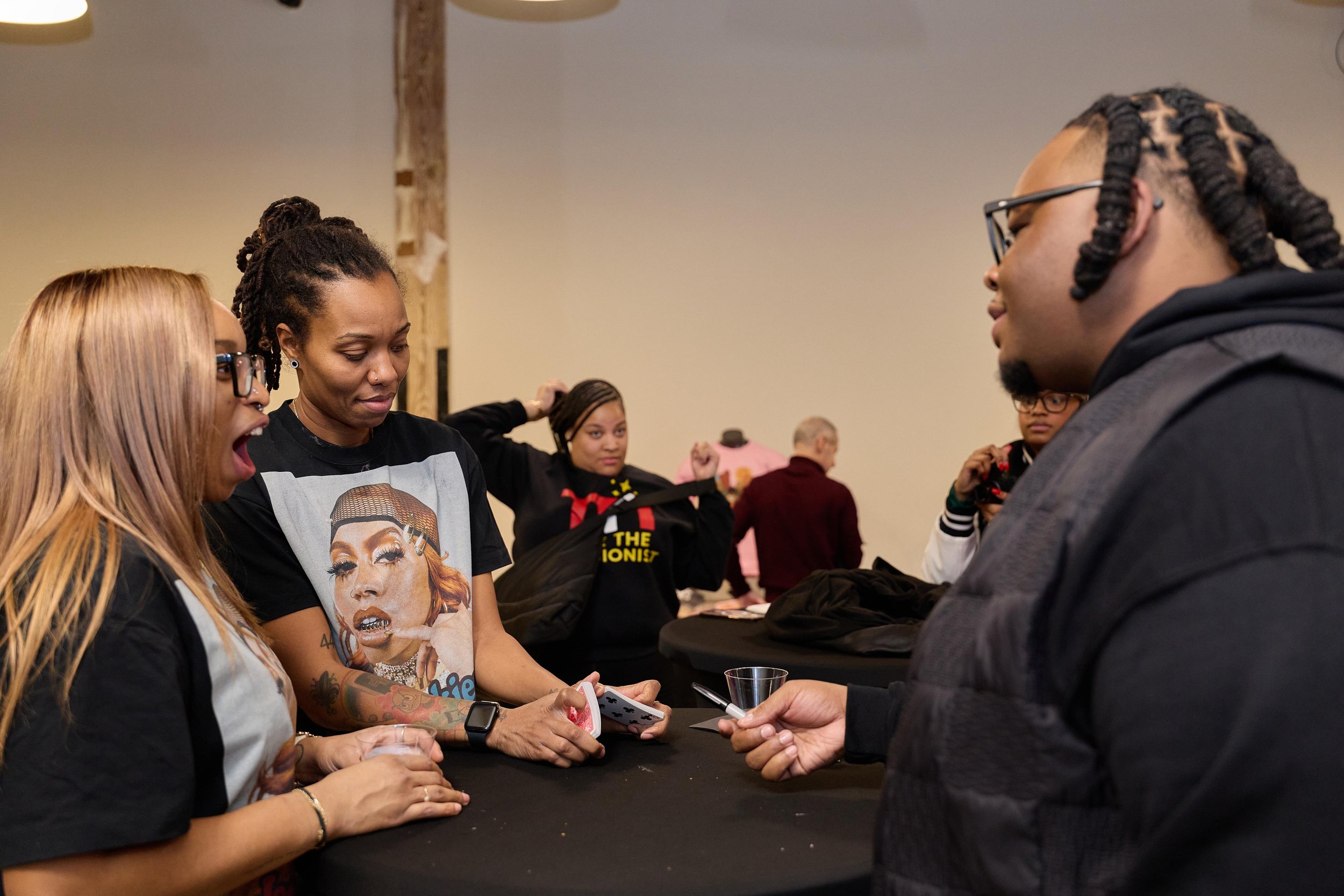 Group of people gathered around a table, engaging in a conversation at Jem Junkies Tooth Gems and  Custom Grillz in Chicago 