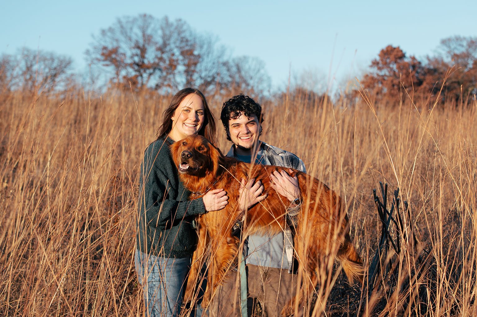 Fall portrait of couple in grass at Lebanon Hills park with their Golden Retriever.