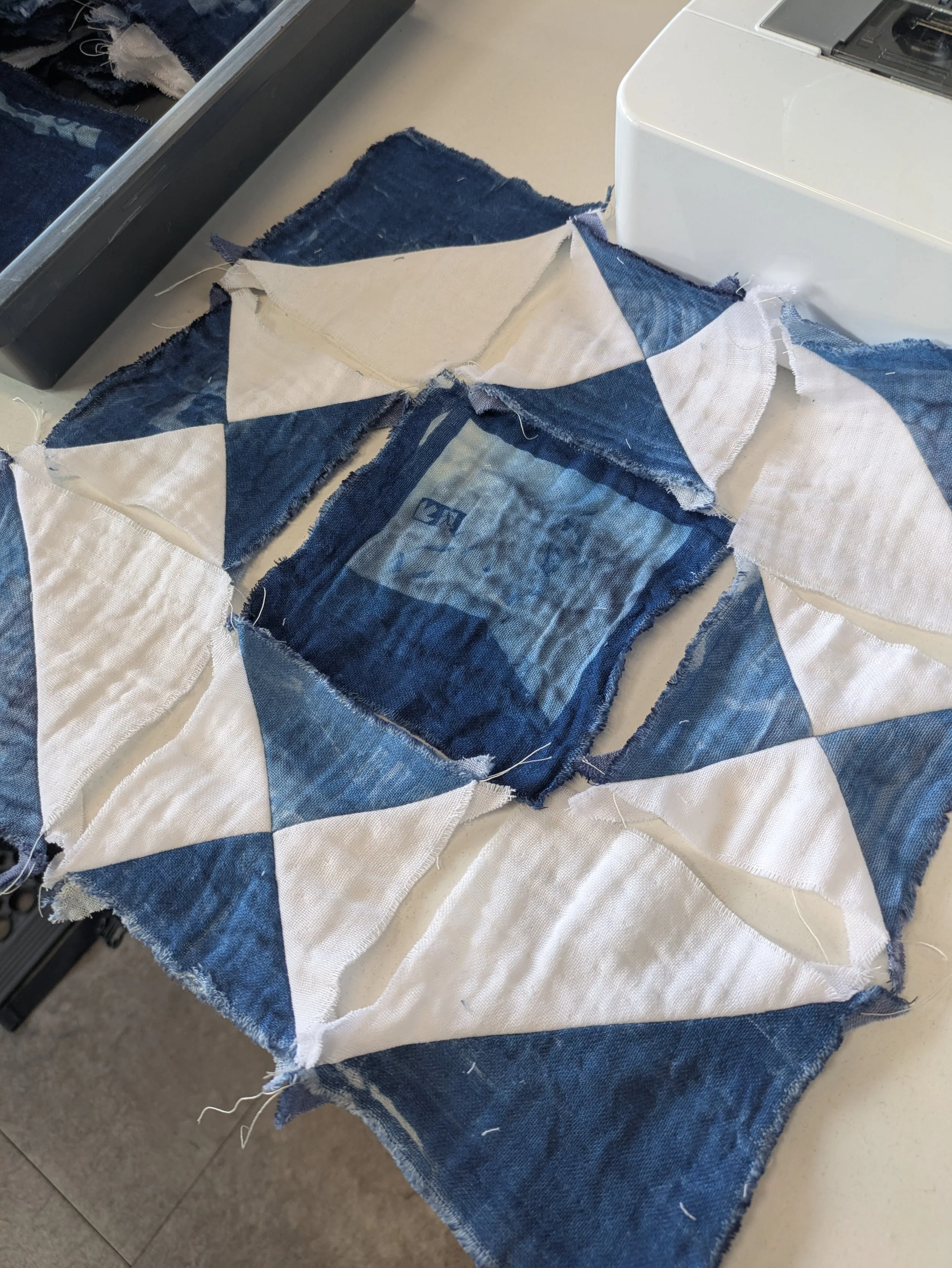 I stared the process of assembling the initial quilt block however, in creating the quarter square triangle sections, realised that too much fabric would be lost to seams to keep the full cyanotyped image in the centre of the block. This lead to rewo