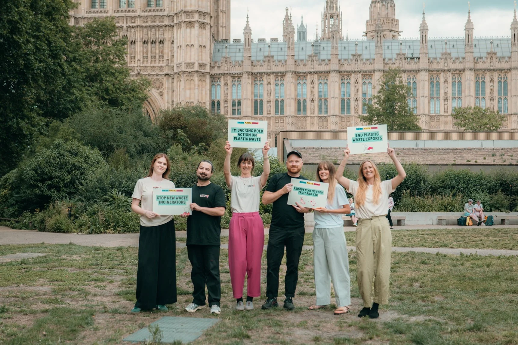 A group of activists holding placards in front of the Houses of Parliament