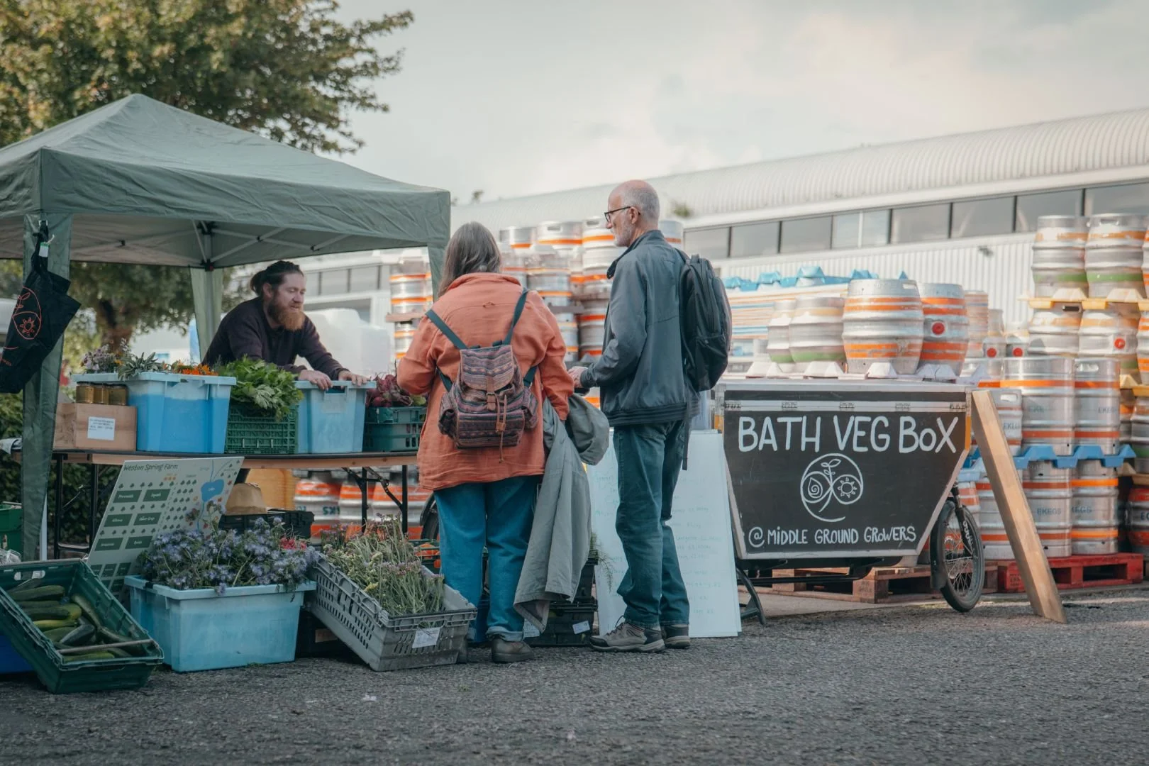 Two people looking at groceries at a farmer's market stall