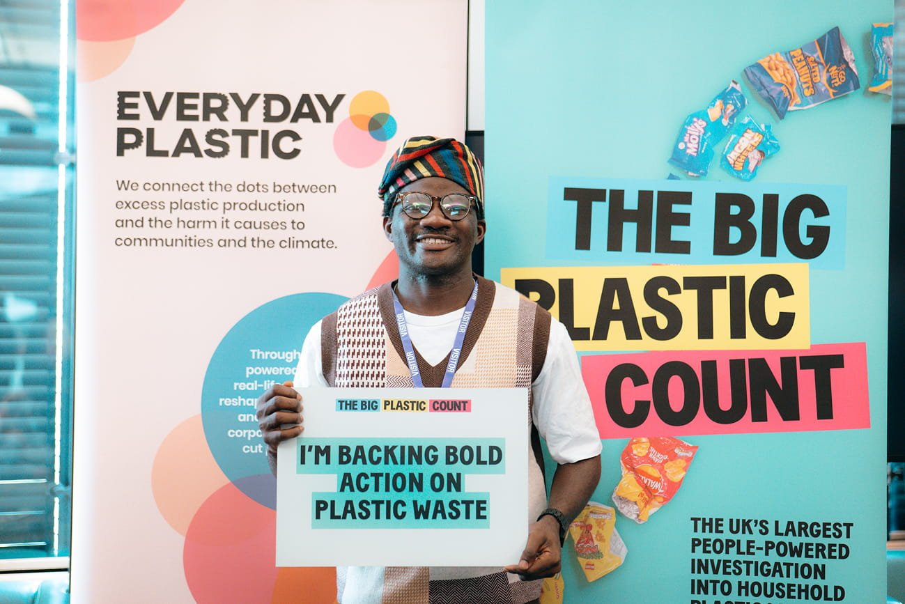 An activist holding a placard saying 'I'm backing bold action on plastic waste'