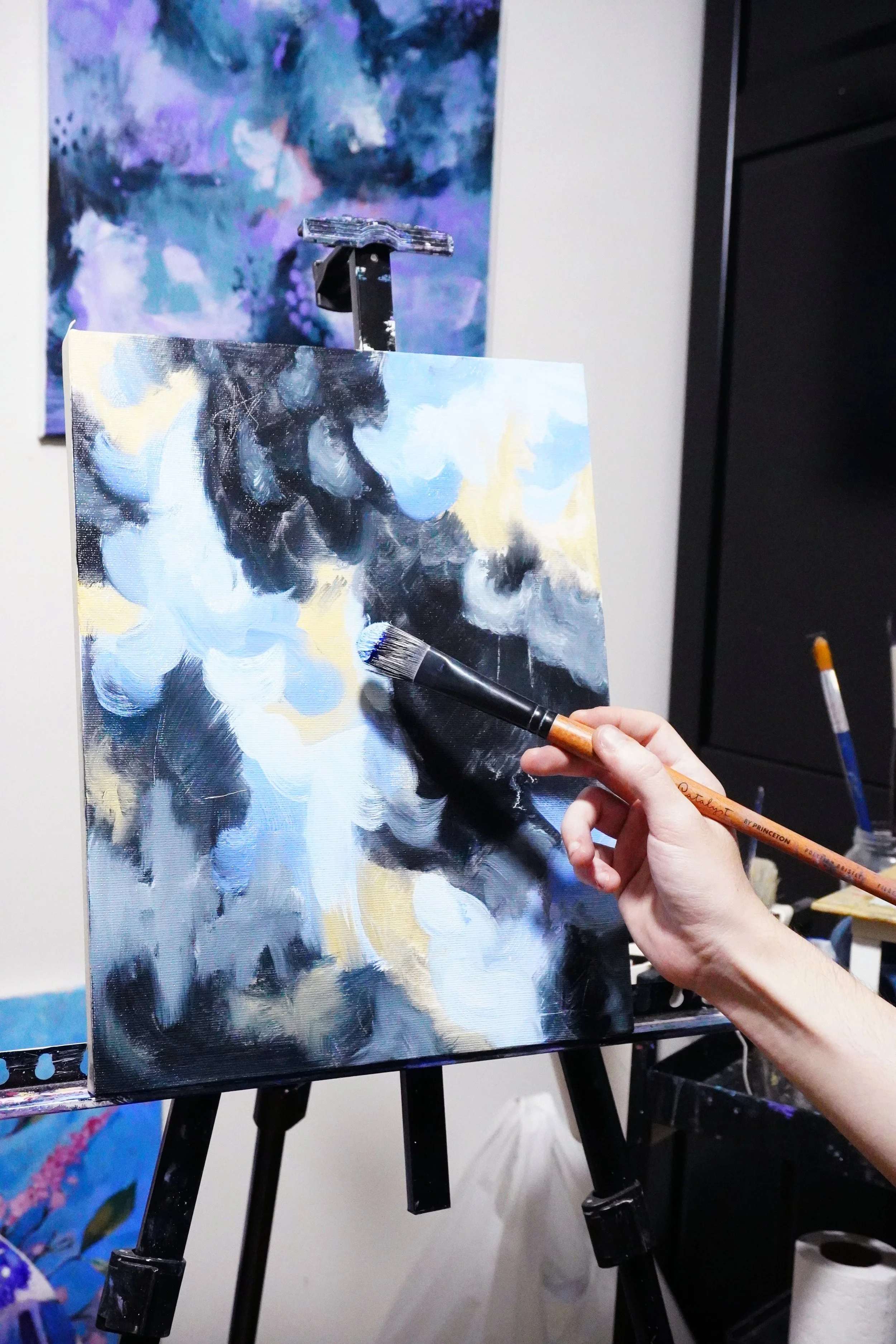 El arista asturiano Daniel Concheso trabajando en su estudio en una pintua en colores negro, azúl y ocres