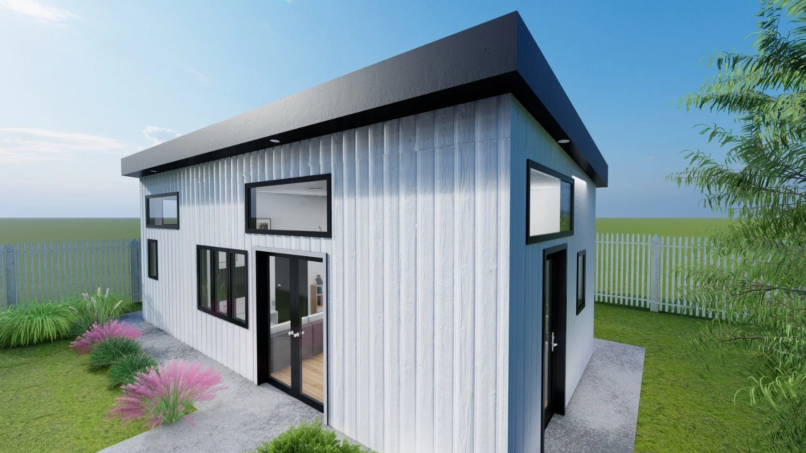 Modern two-story house with black-framed windows and a white exterior, situated in a grassy yard with a white fence and some pink and green plants.