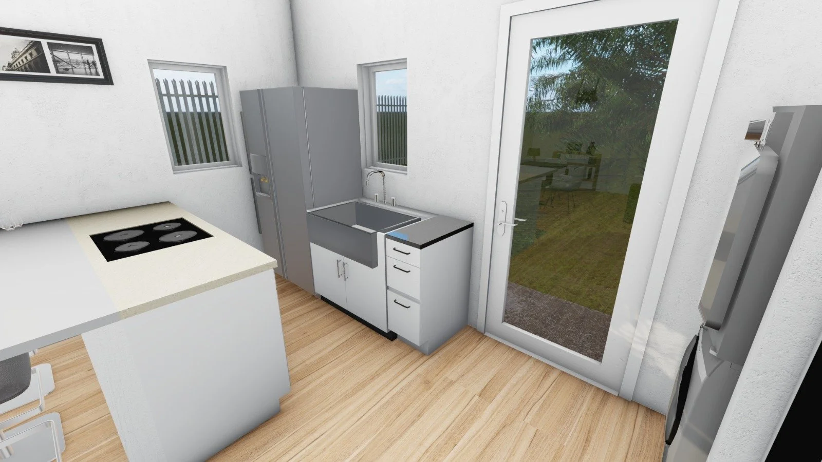 Kitchen with white cabinets, a gray refrigerator, a sink under a window, and a glass door leading outside. There is a black stovetop on the white countertop and a washing machine and dryer on the right side.