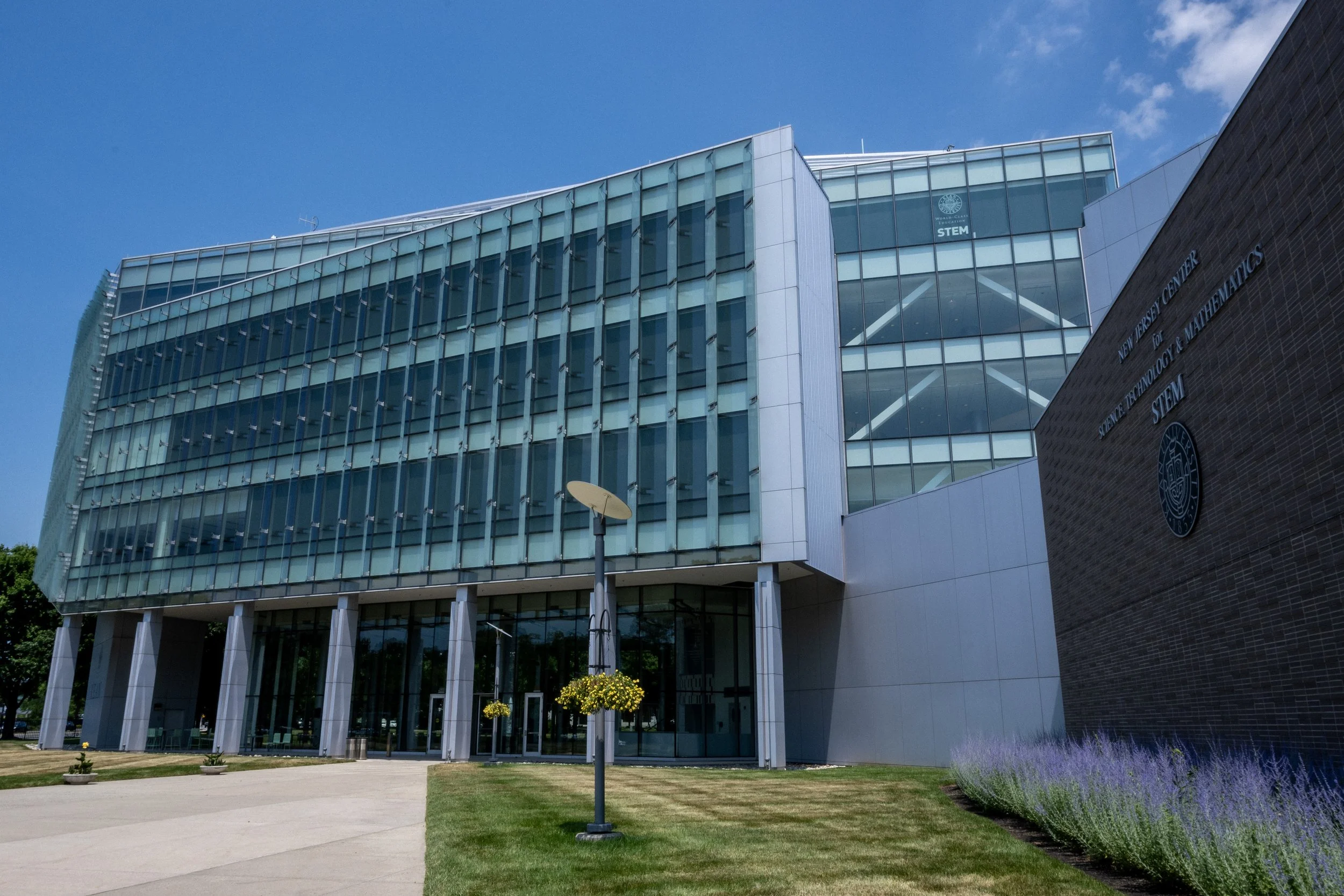 Modern building with glass facade labeled "New Jersey Center for Science, Technology, & Mathematics STEM."