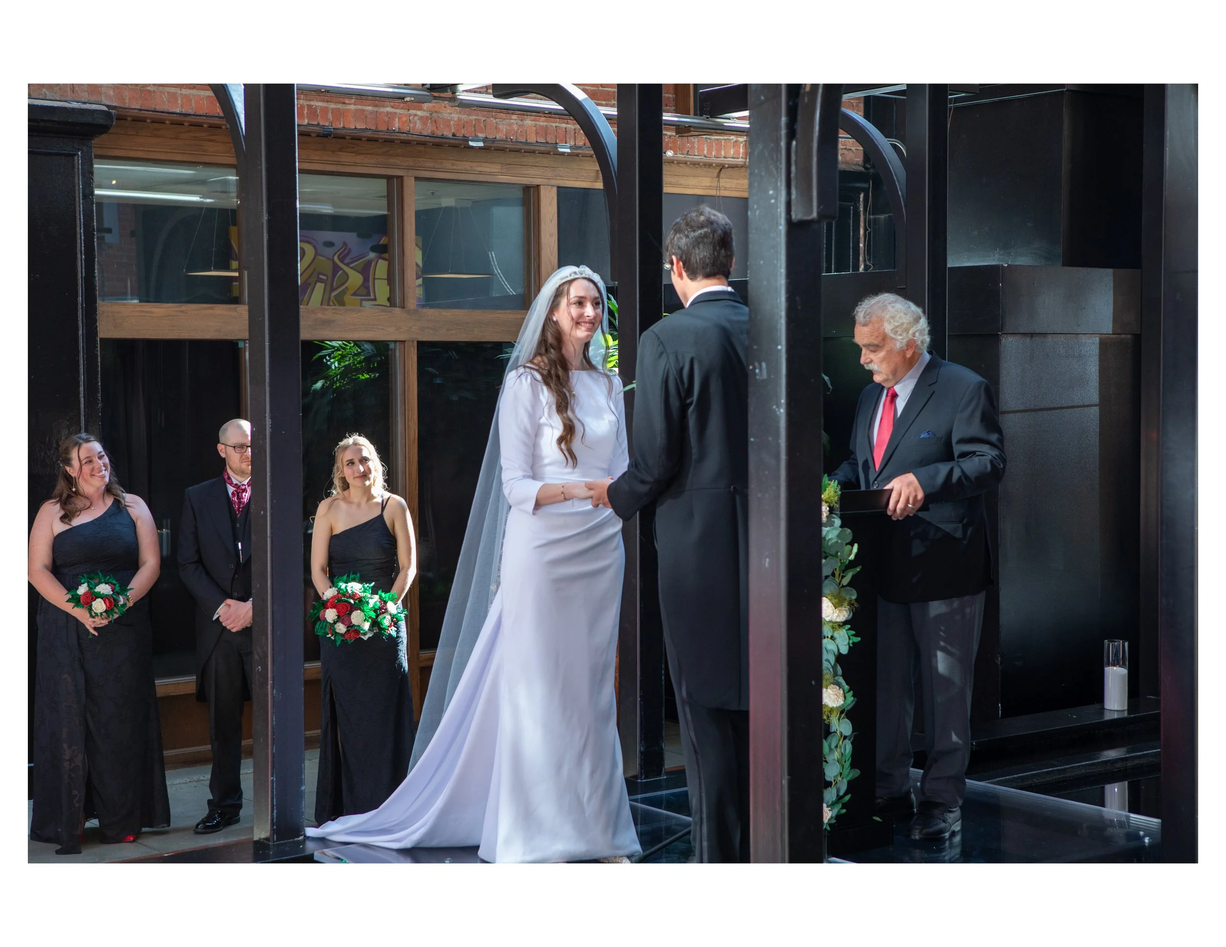 A wedding ceremony with a bride and a groom exchanging vows in front of friends and family.