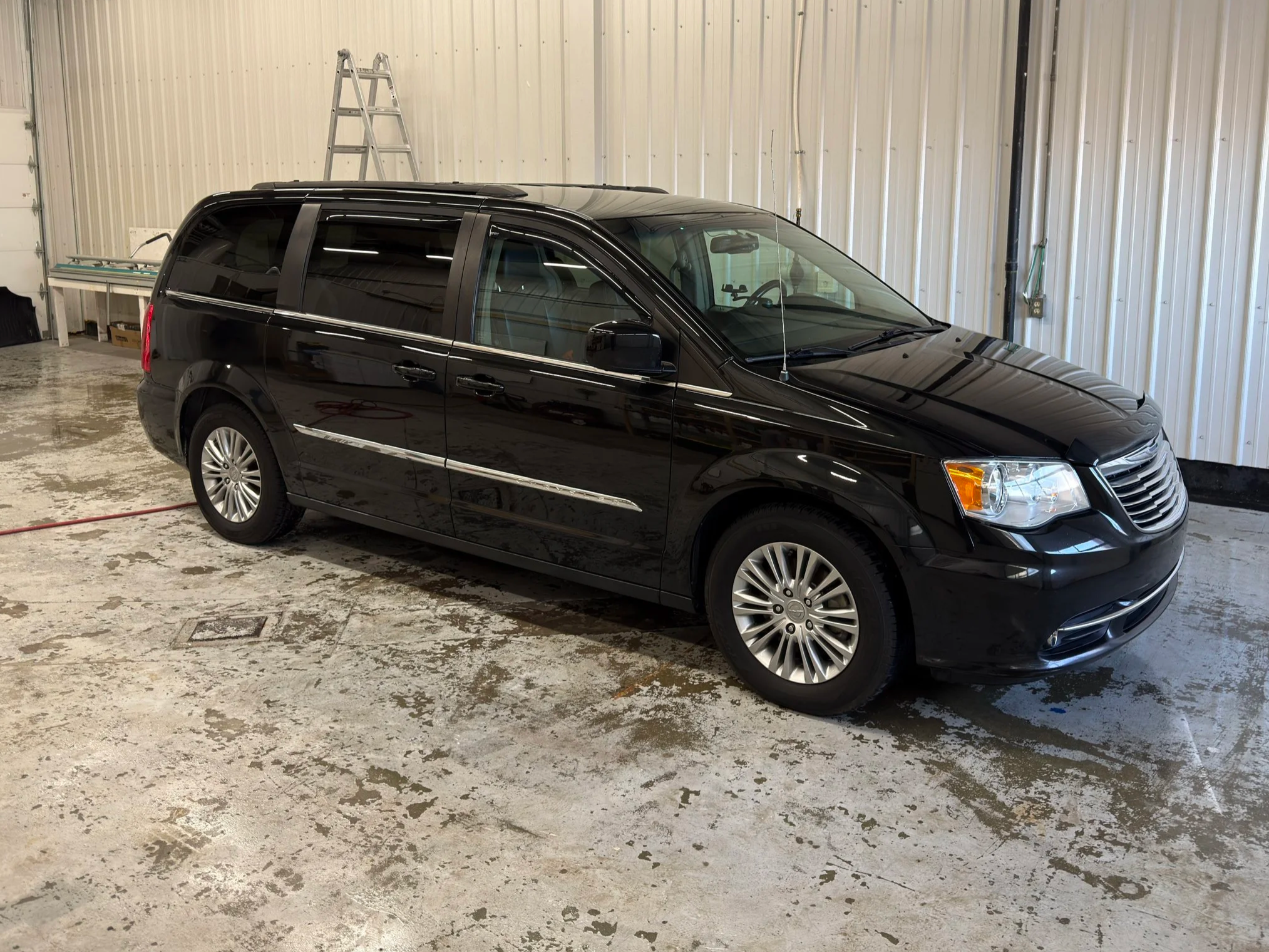 Full exterior wash and shine on a white passenger van in Didsbury, Alberta.
