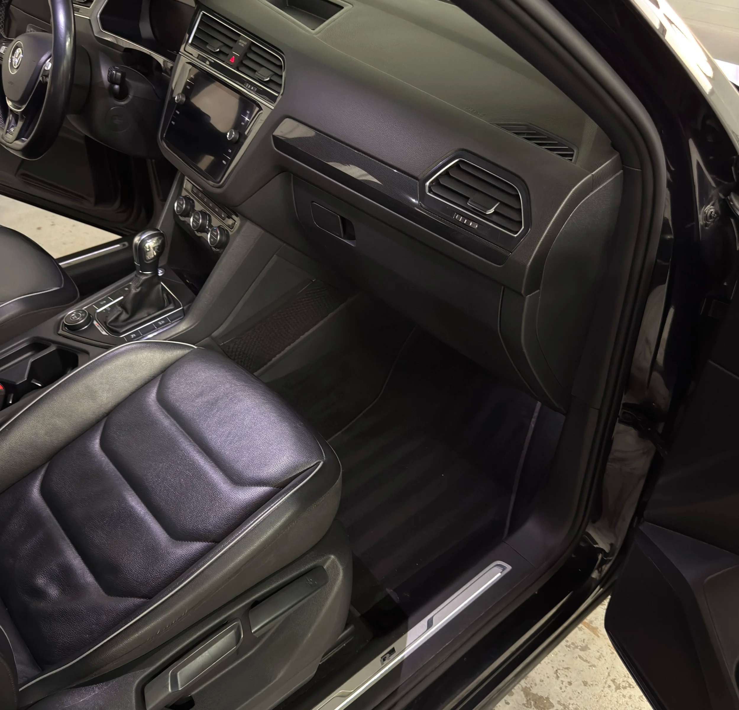 Passenger side carpet and floor mat freshly shampooed with vacuum lines for a perfect interior detail.