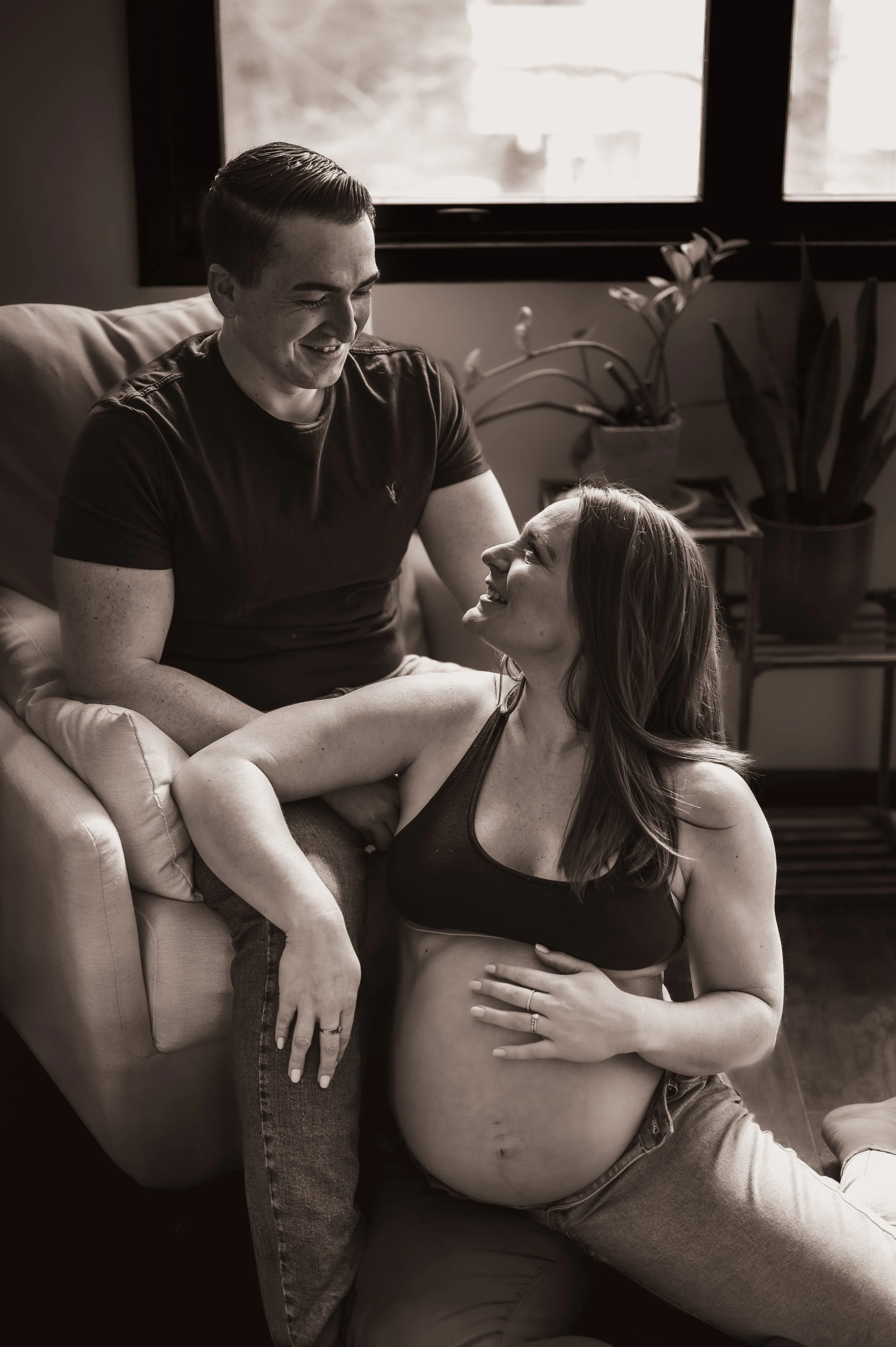 A couple smiling at each other expecting their first child