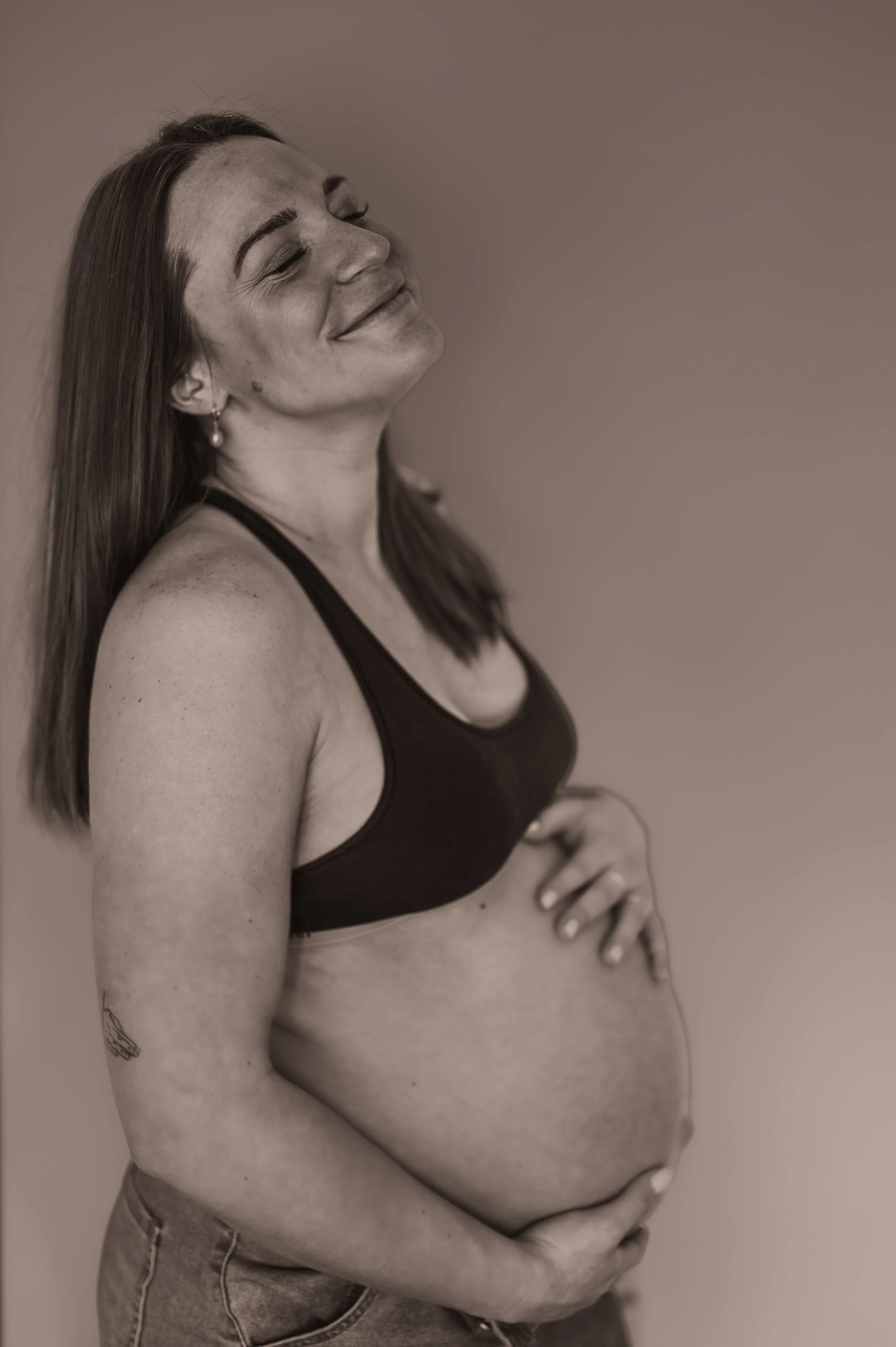 A black and white image of a beautiful pregnant woman