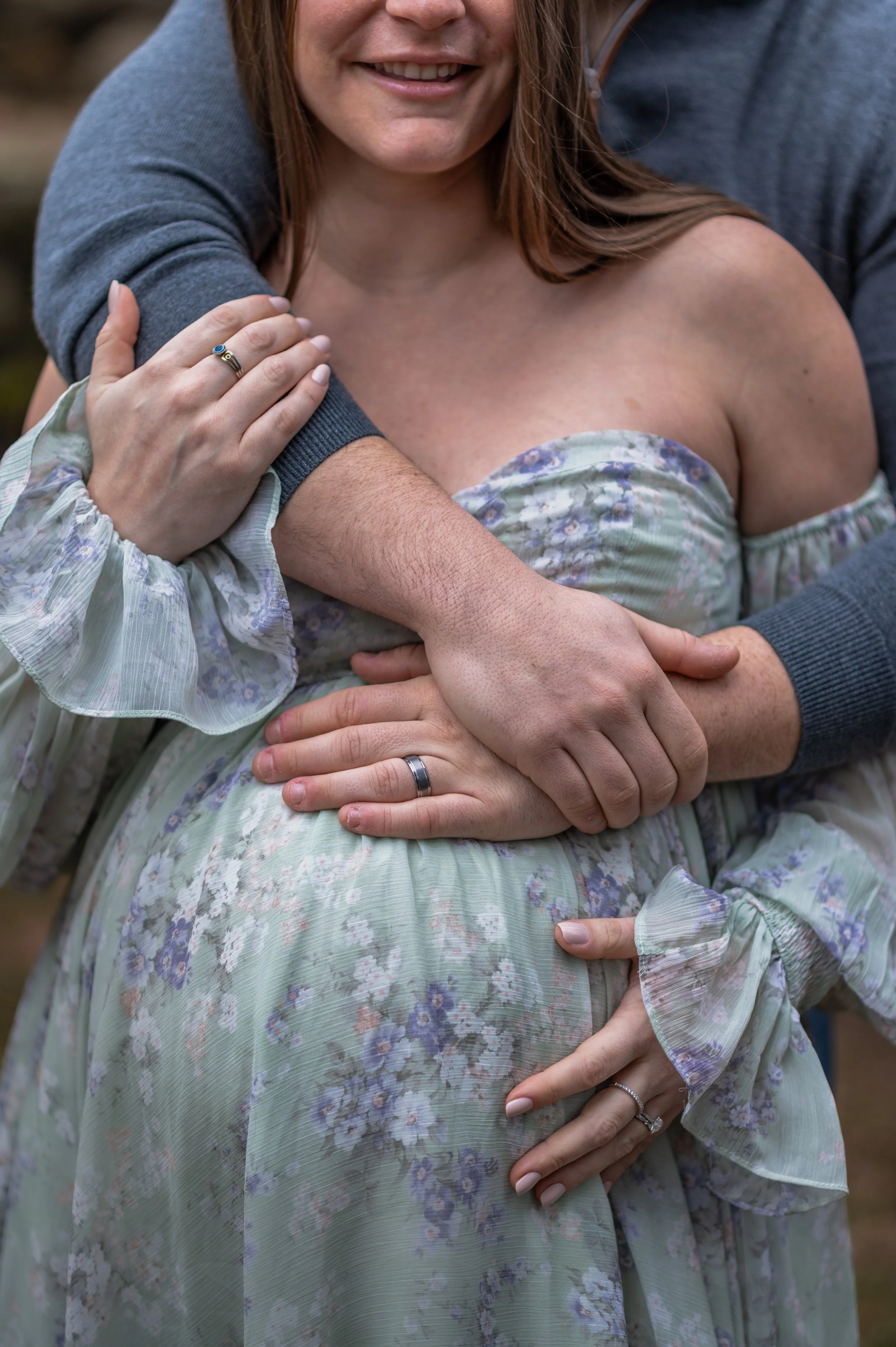 A close up of a couple hugging each other, expecting first child