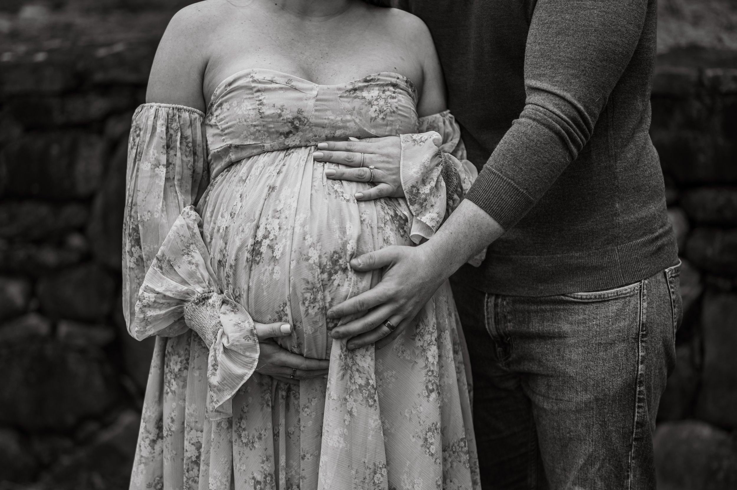 A black and white close up of a pregnant belly