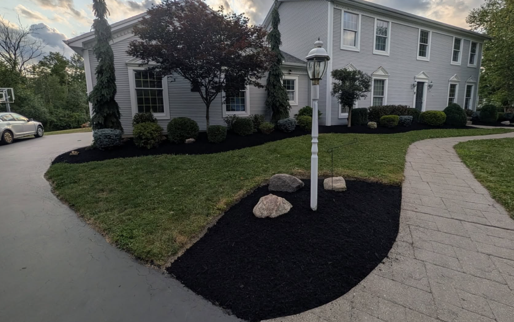 Completed front yard landscape maintenance with fresh black mulch, trimmed shrubs, and professionally maintained planting beds by Kielty Landscaping.