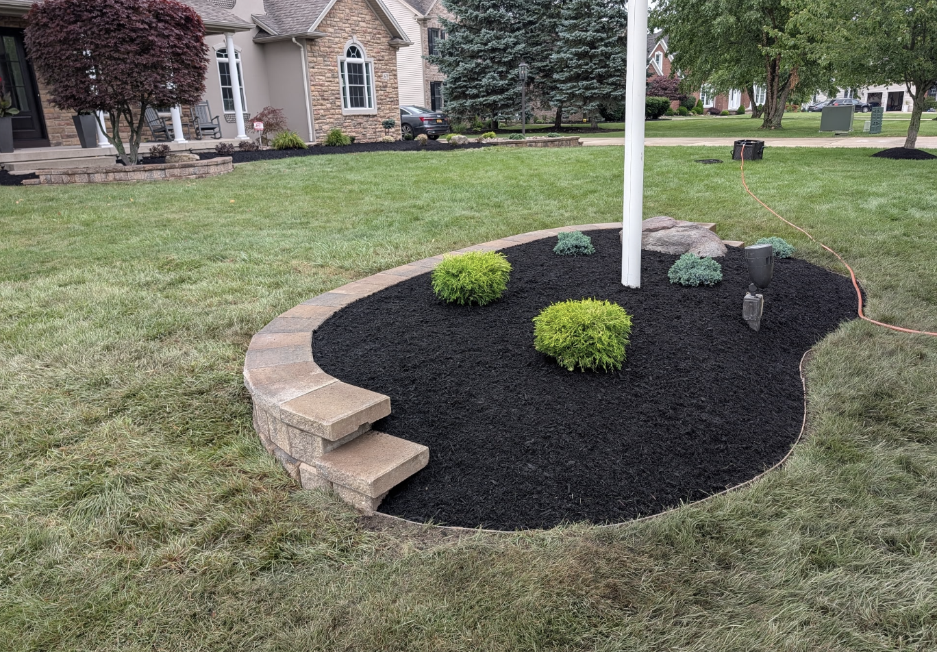 Landscape island bed with new retaining wall, mulch, and plantings installed by Kielty Landscaping in Grand Island, NY