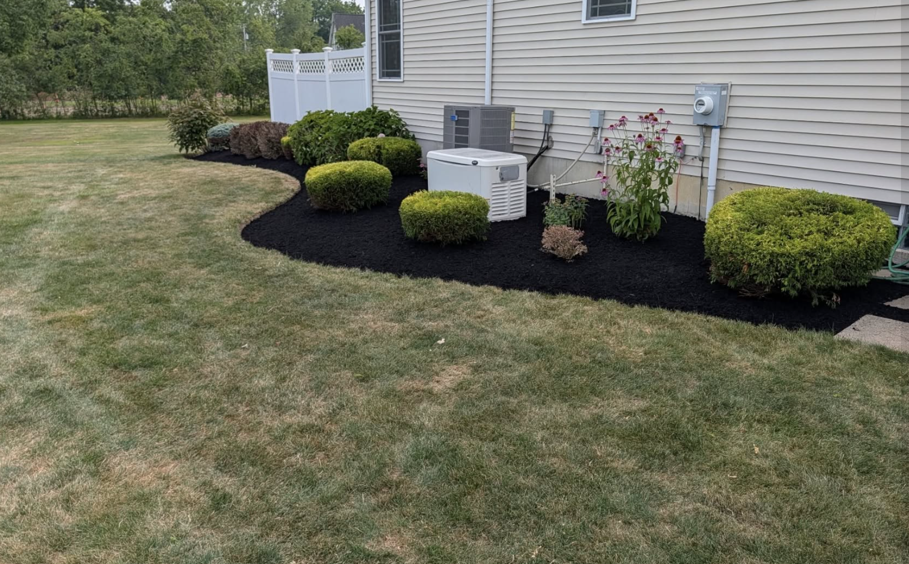 Cleaned and freshly mulched foundation landscape bed around a Grand Island, NY home