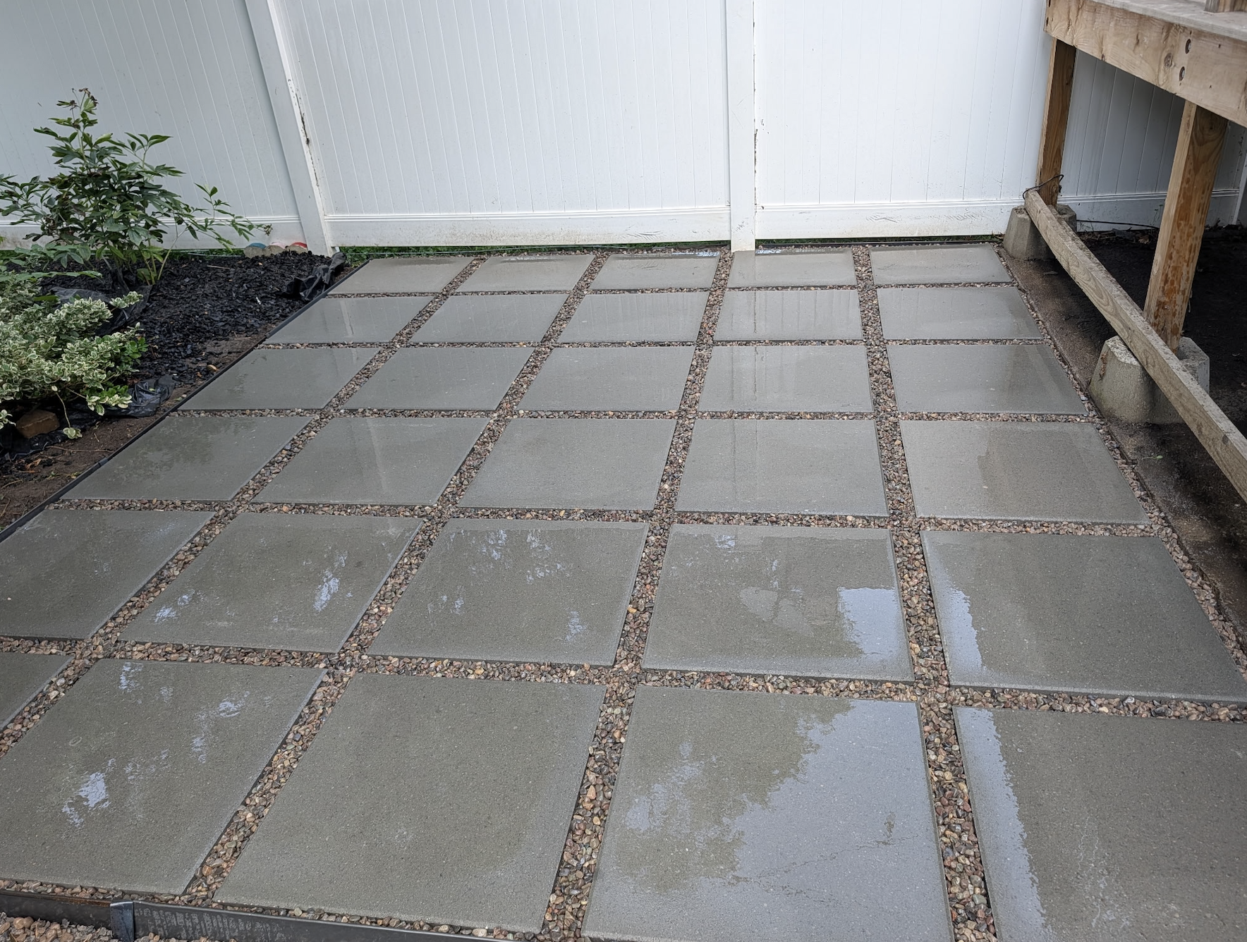 Finished backyard patio featuring large pavers with pea gravel set between each paver