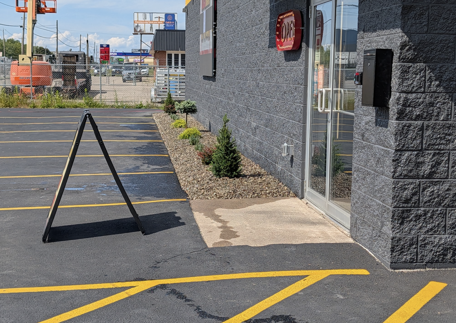 Commercial landscape design with decorative stone and shrubs near building entrance