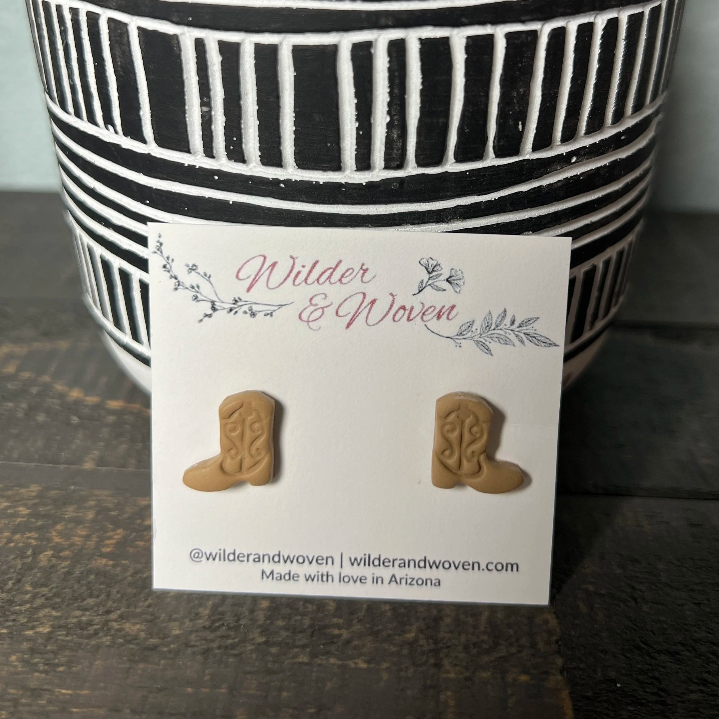 Handcrafted polymer clay cowgirl boot stud earrings in a soft blush pink tone, displayed on a Wilder & Woven branded jewelry card.