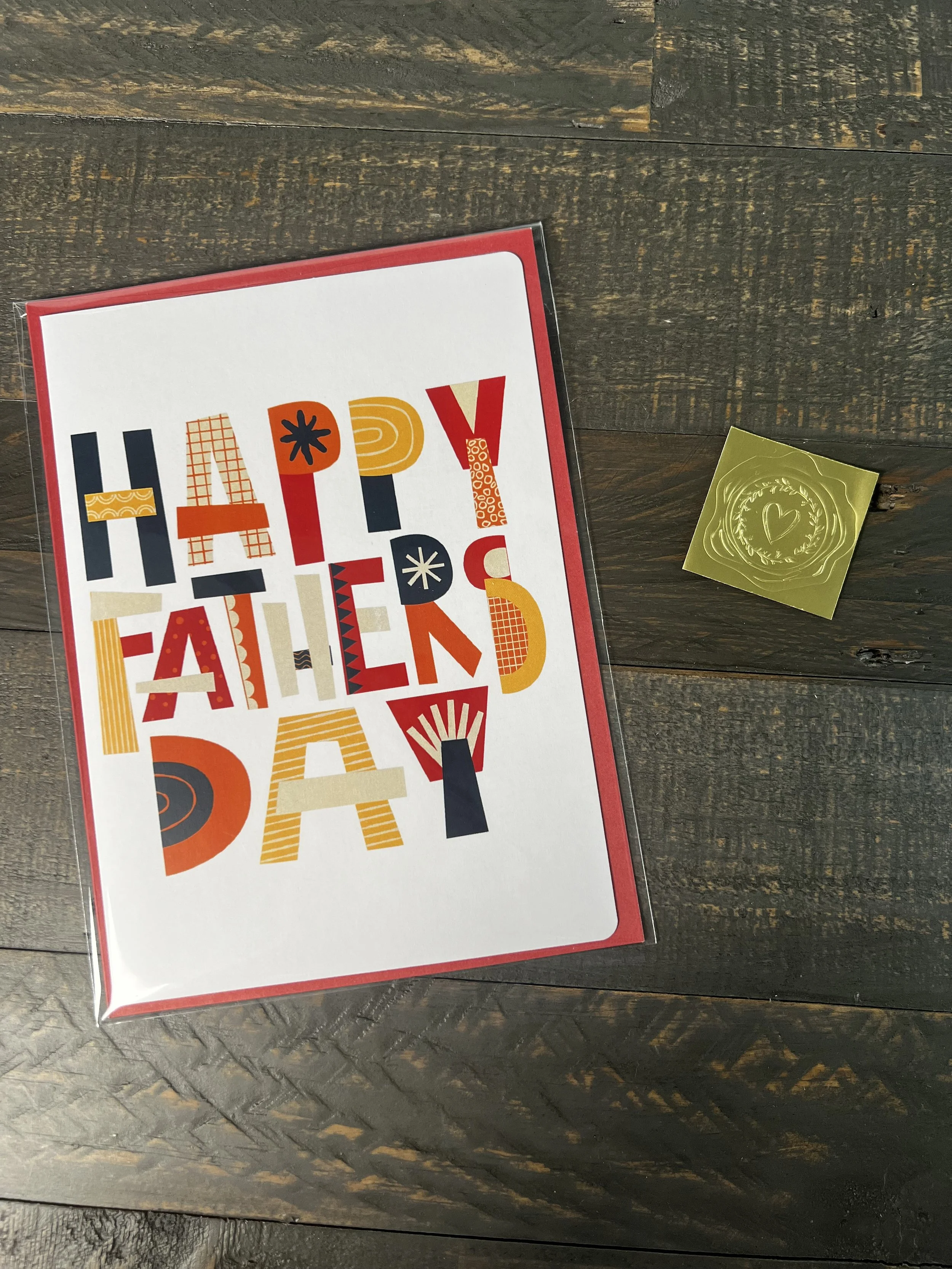 Colorful Father’s Day card styled with coordinating red envelope and gold wax seal sticker