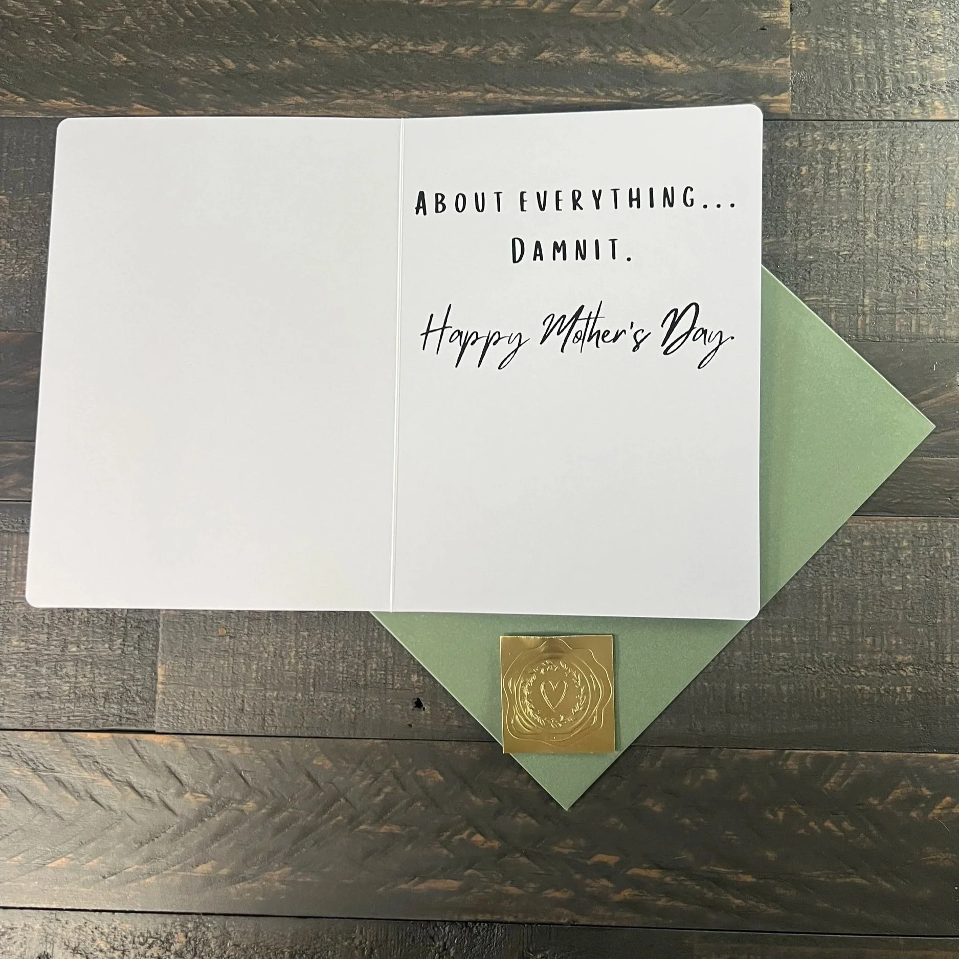 Inside of humorous Mother’s Day card with minimalist text and clean layout, displayed with sage green envelope and gold wax seal sticker