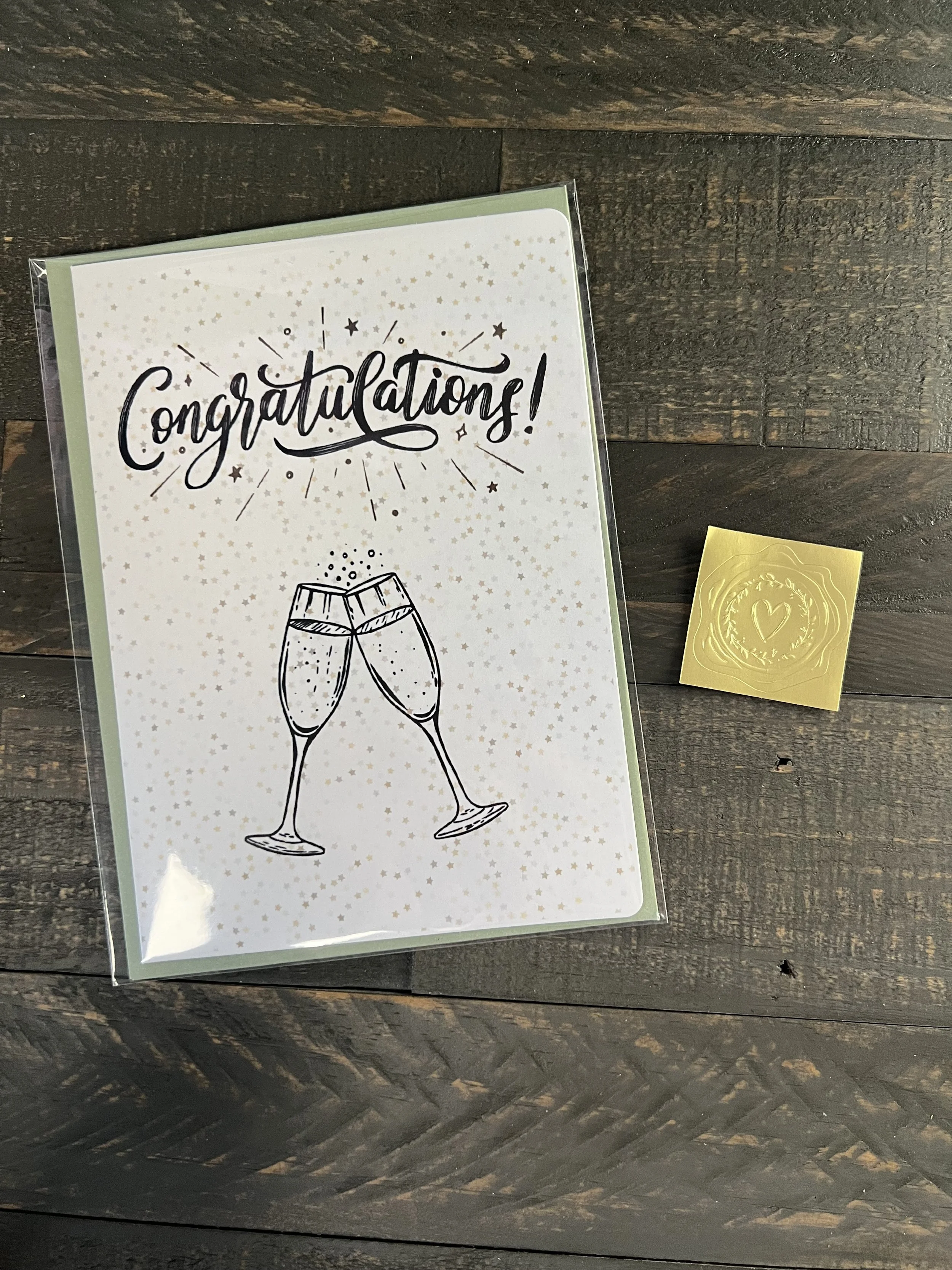 Congratulations card with coordinating envelope and gold wax seal sticker styled on rustic wood surface