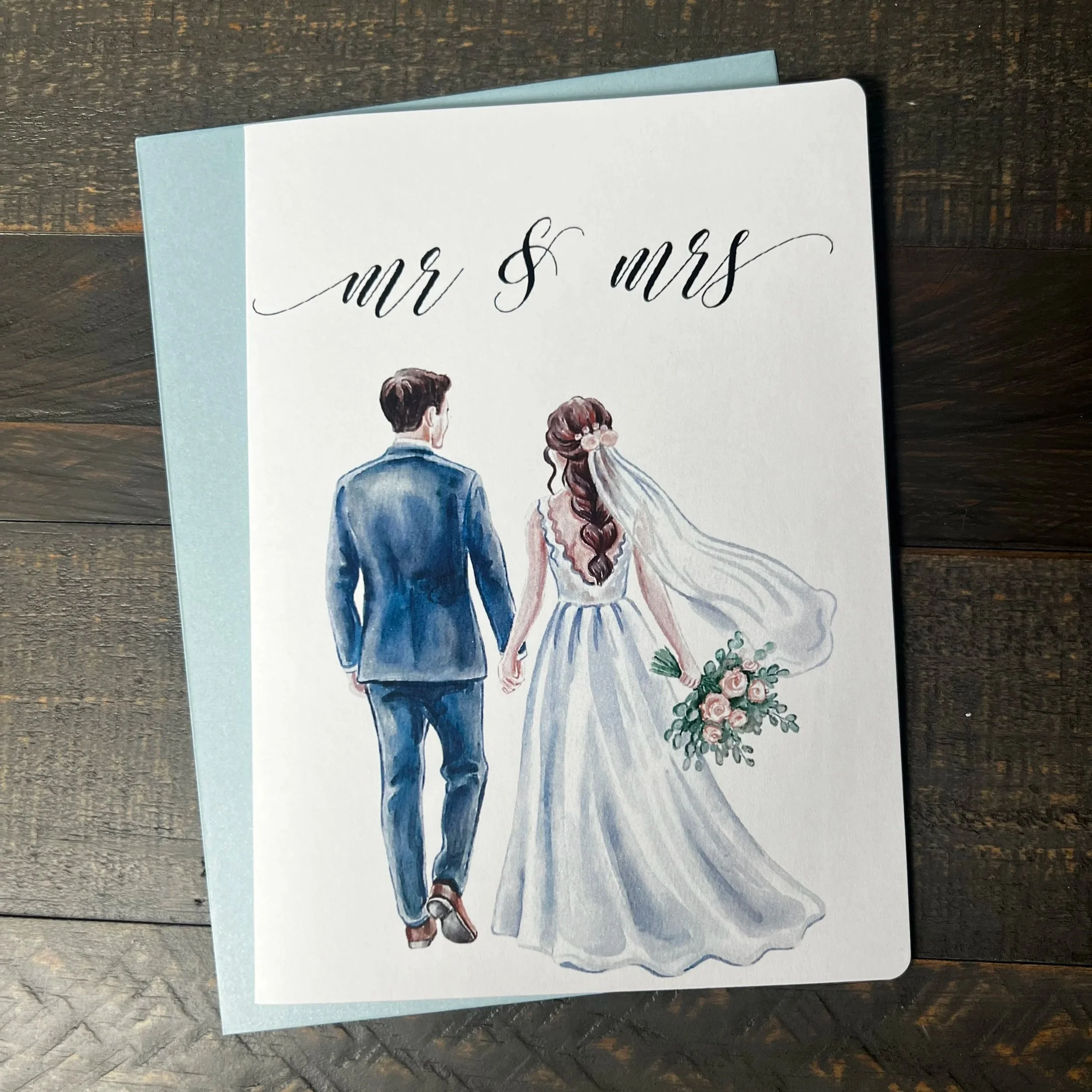 Front of Mr. & Mrs. wedding greeting card featuring a brunette bride with coordinating soft blue envelope.