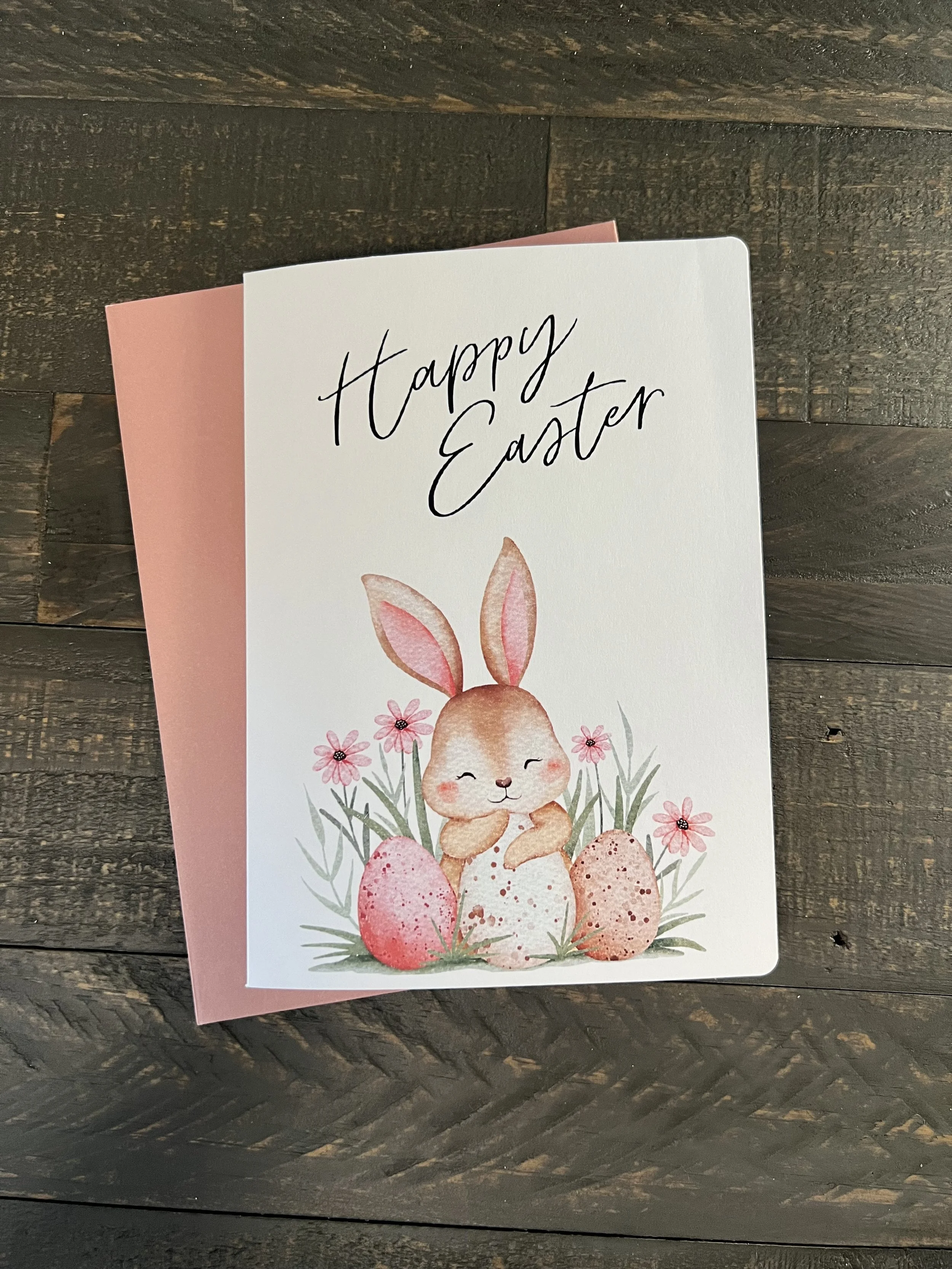 Easter bunny greeting card with floral design and soft pastel colors on rustic wood background