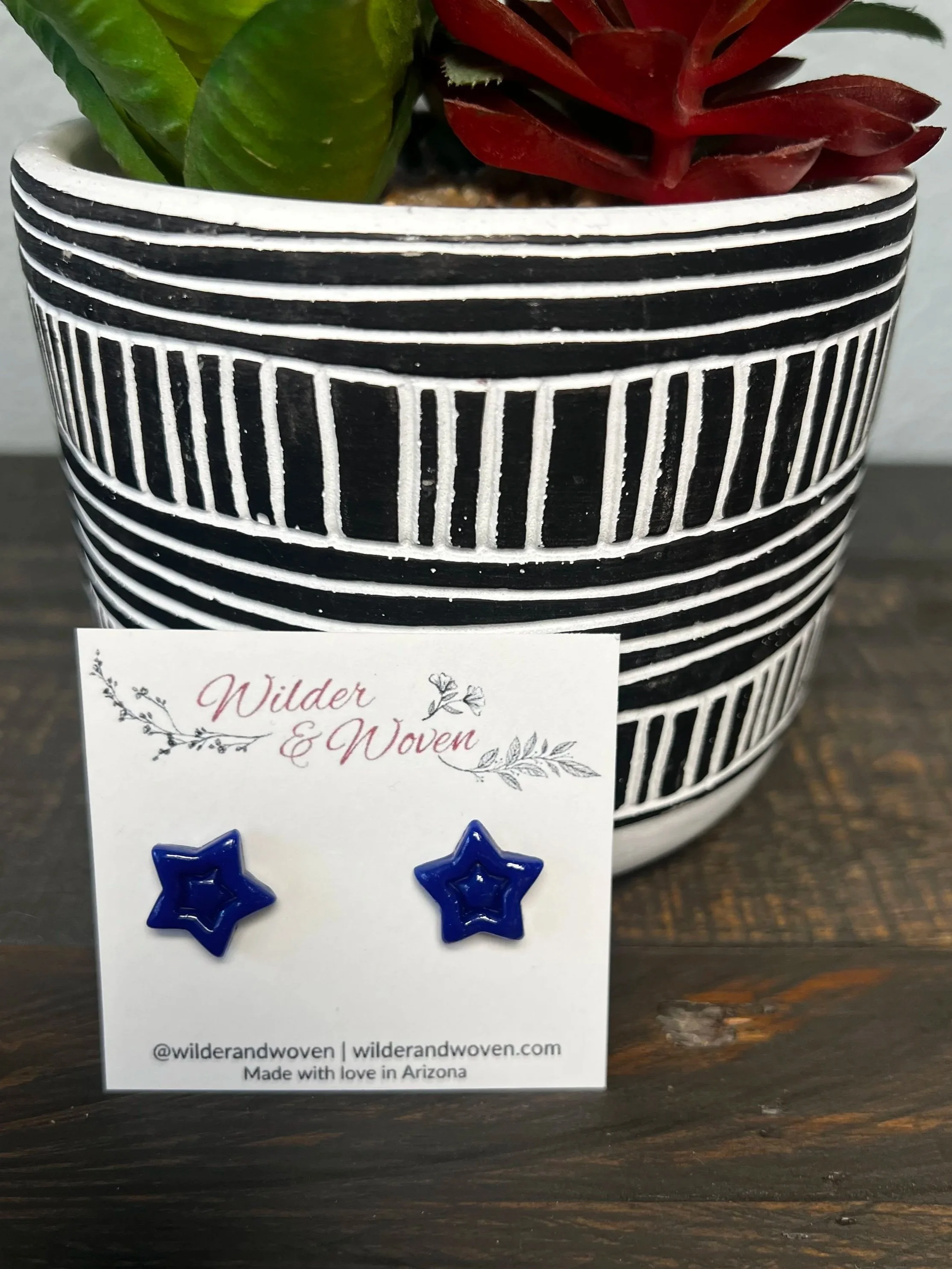 Handmade navy blue polymer clay star stud earrings displayed on a Wilder & Woven earring card.