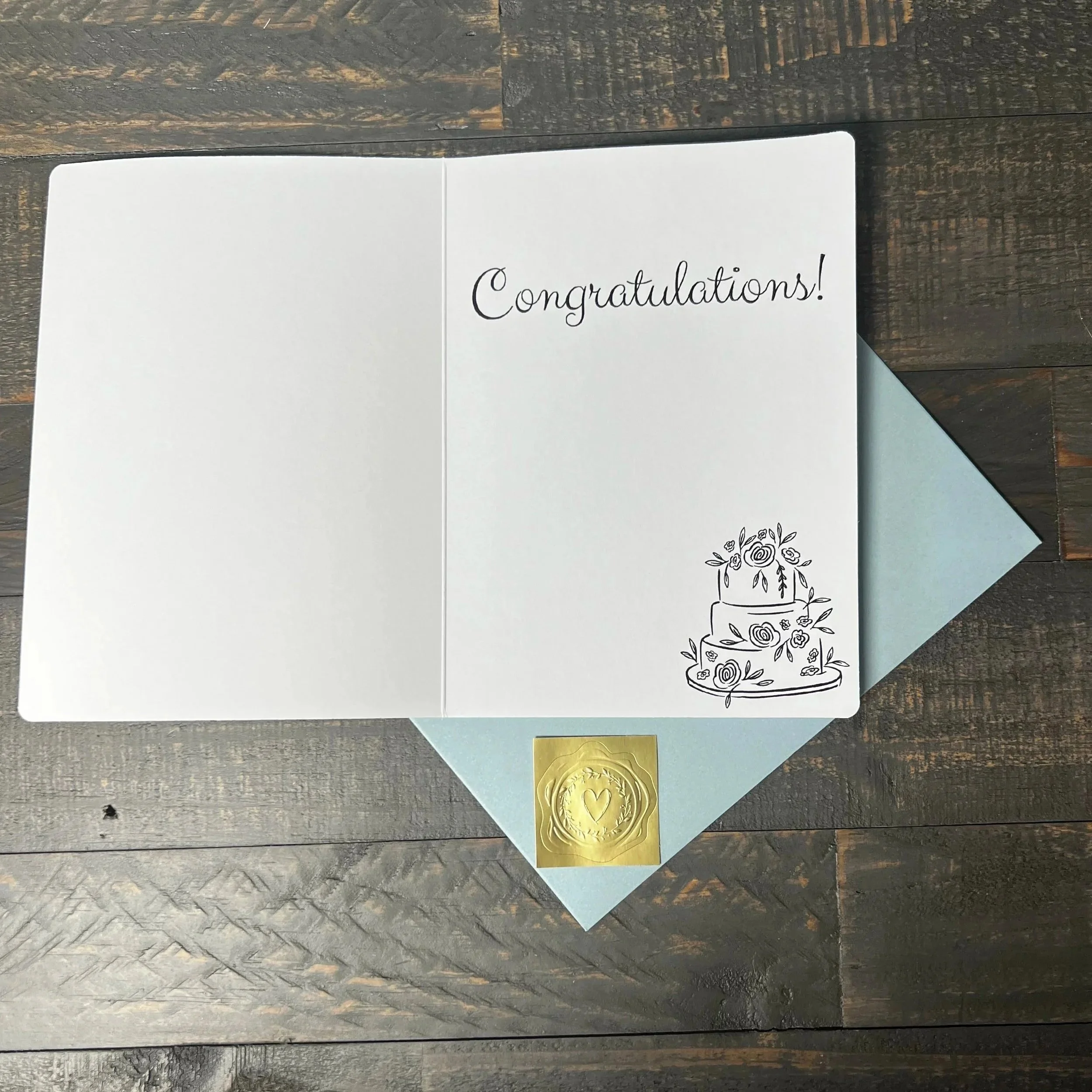 Open Happy Wedding Day Card with coordinating soft blue envelope and gold wax seal style sticker.