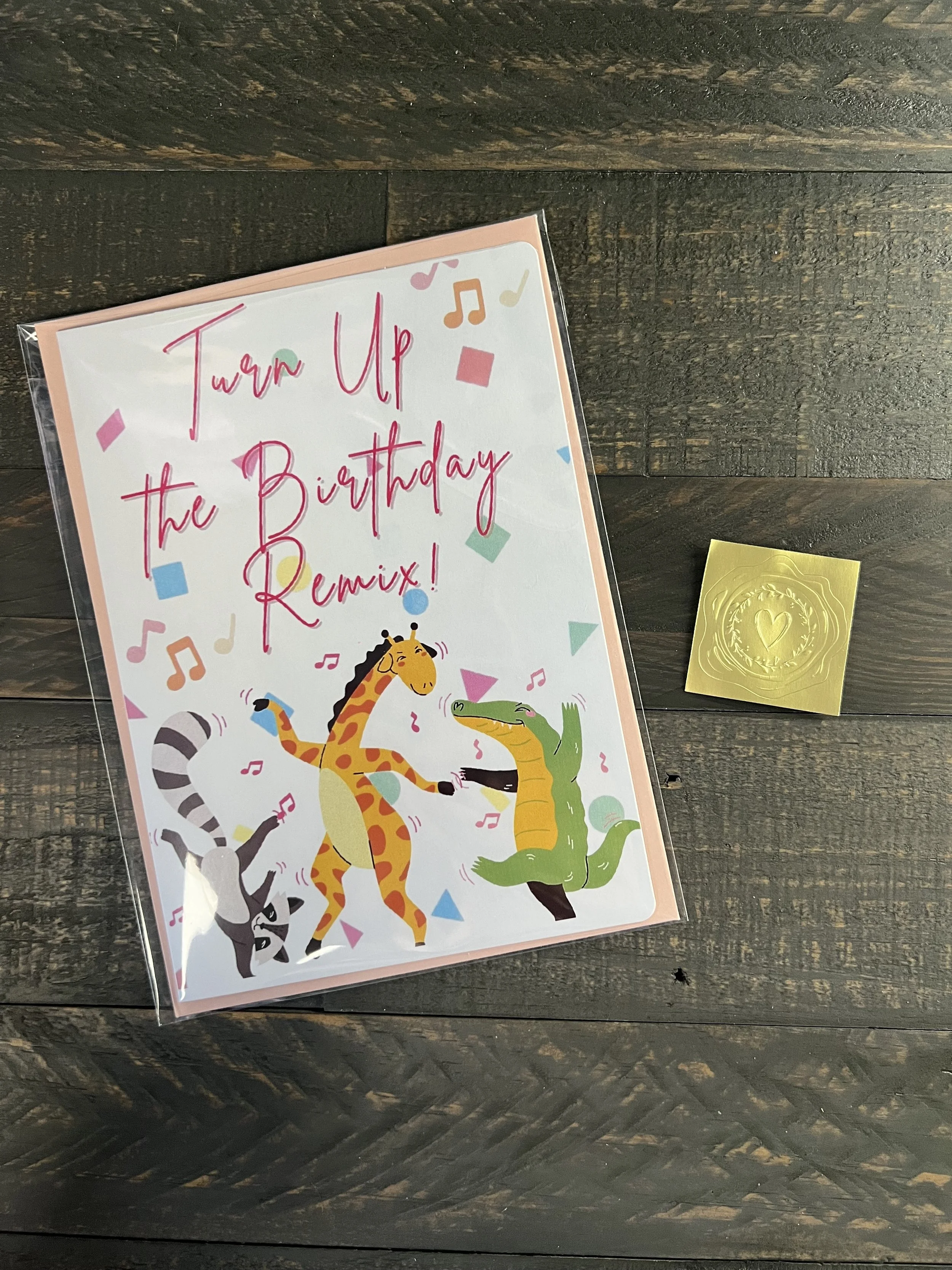 Birthday card with coordinating envelope and gold wax seal sticker styled on neutral surface