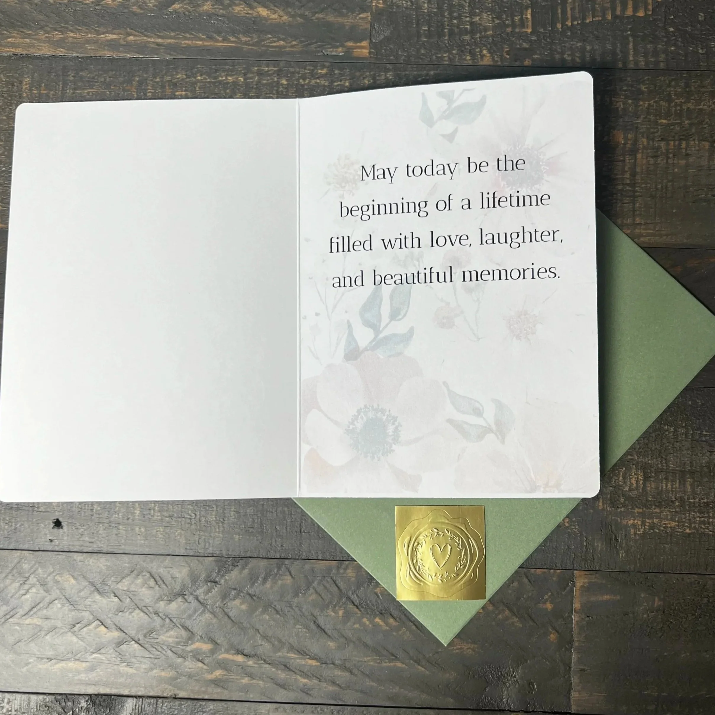 Open Beginning of a Lifetime Wedding Card with coordinating sage green envelope and gold wax seal style sticker.