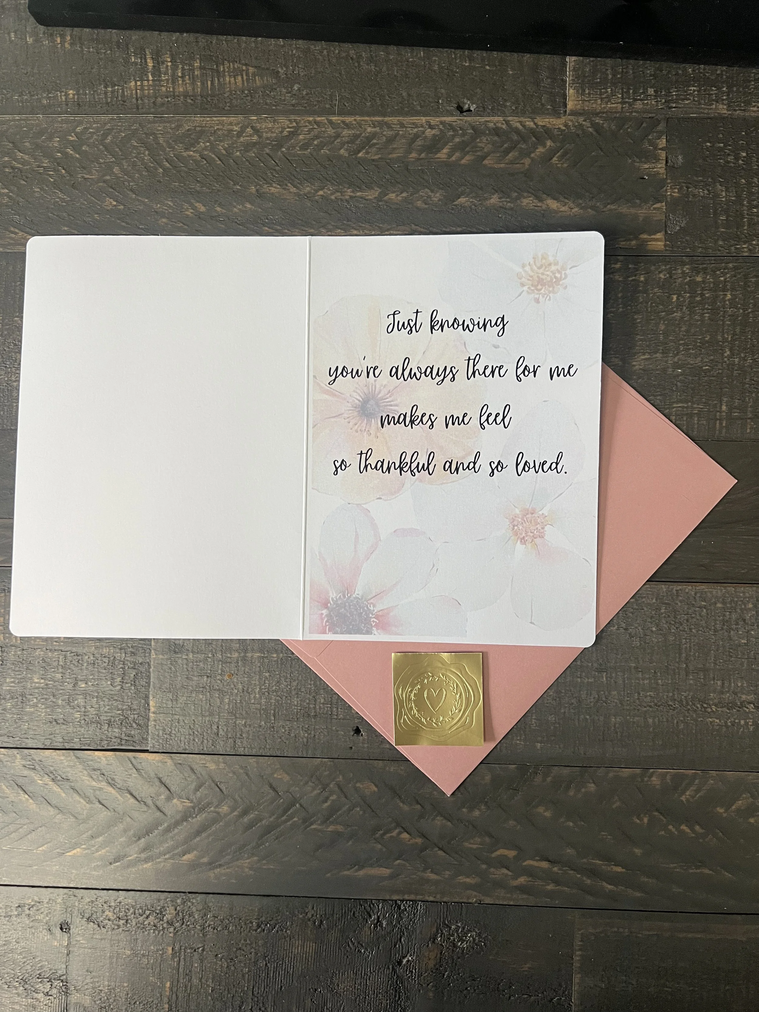 Inside of Mother’s Day card with soft floral background, heartfelt message, blush envelope, and gold wax seal sticker styled on wood surface
