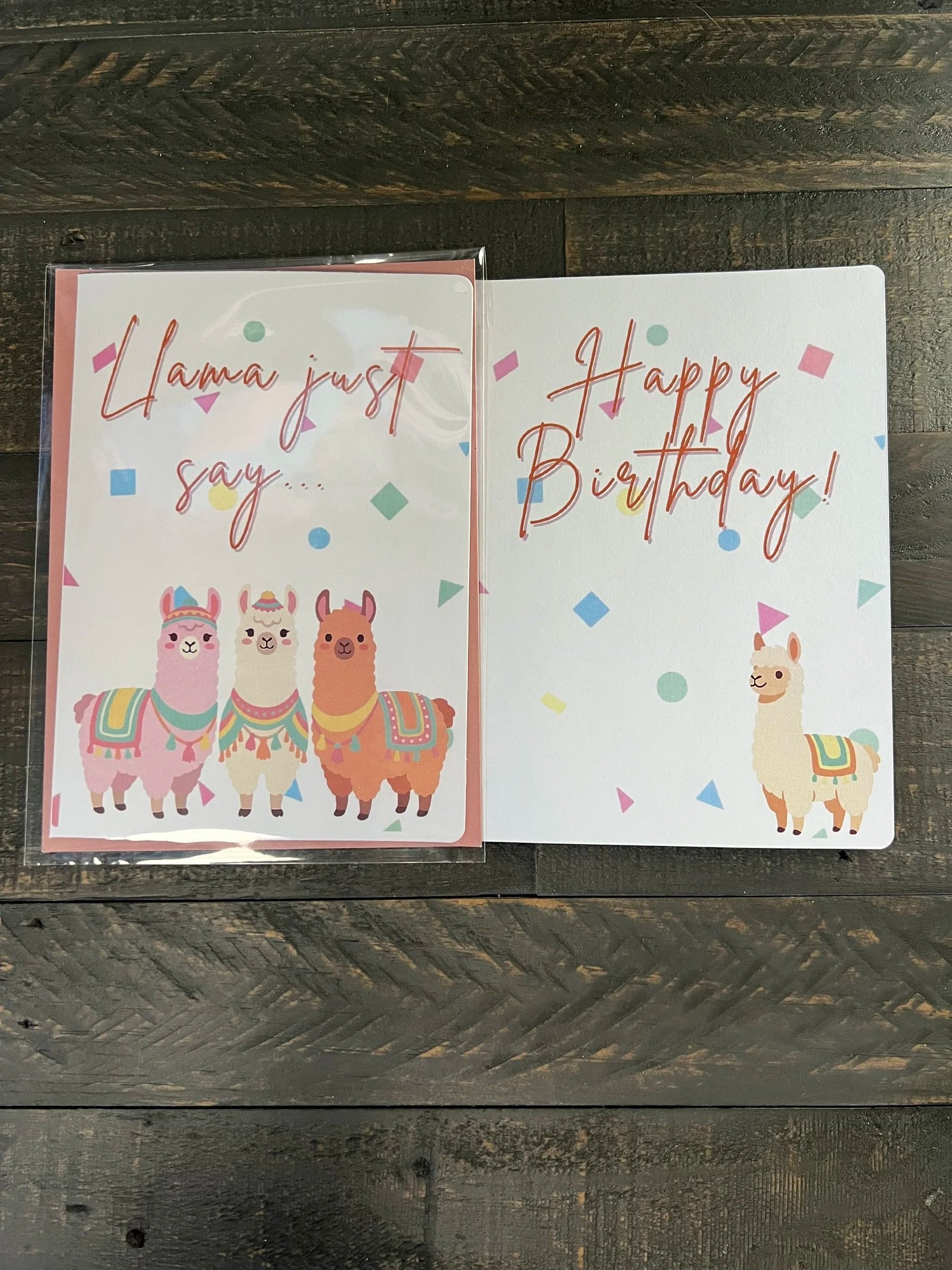 Open birthday card showing inside message "happy birthday!" with llama design on front