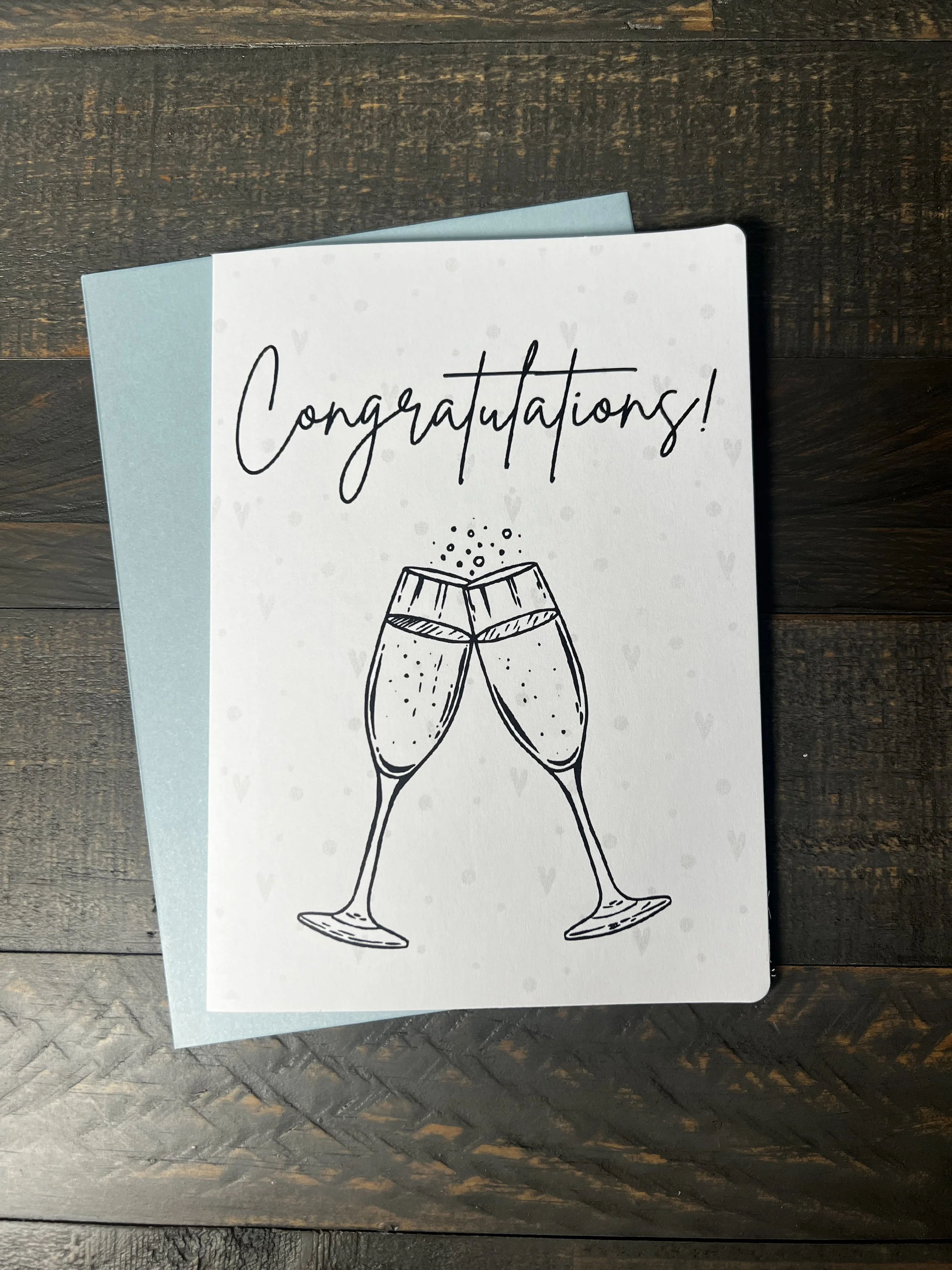 Front of Cheers to Happily Ever After Wedding Card with coordinating soft blue envelope.