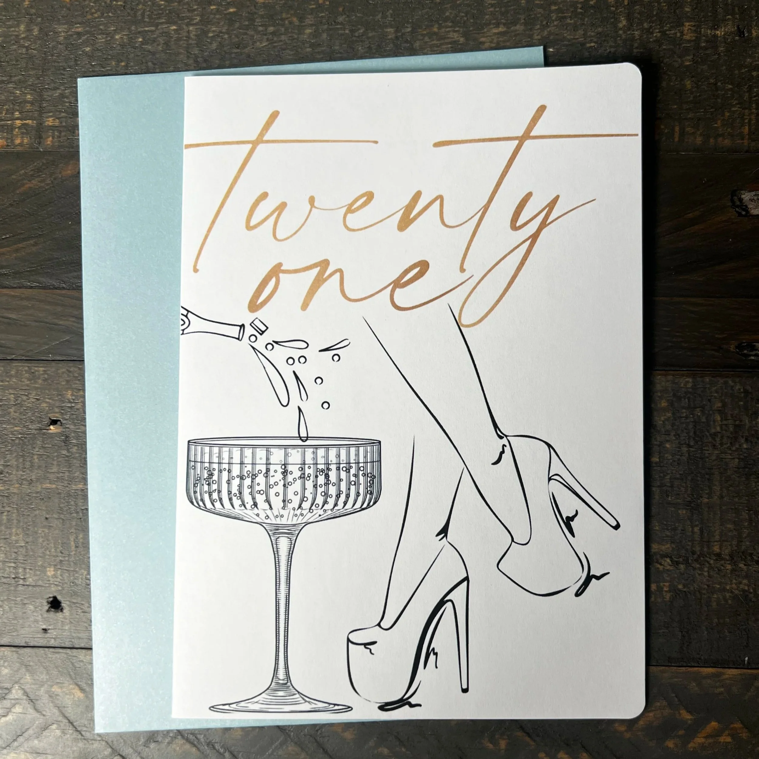 Twenty One birthday greeting card featuring champagne glass and elegant heels illustration.