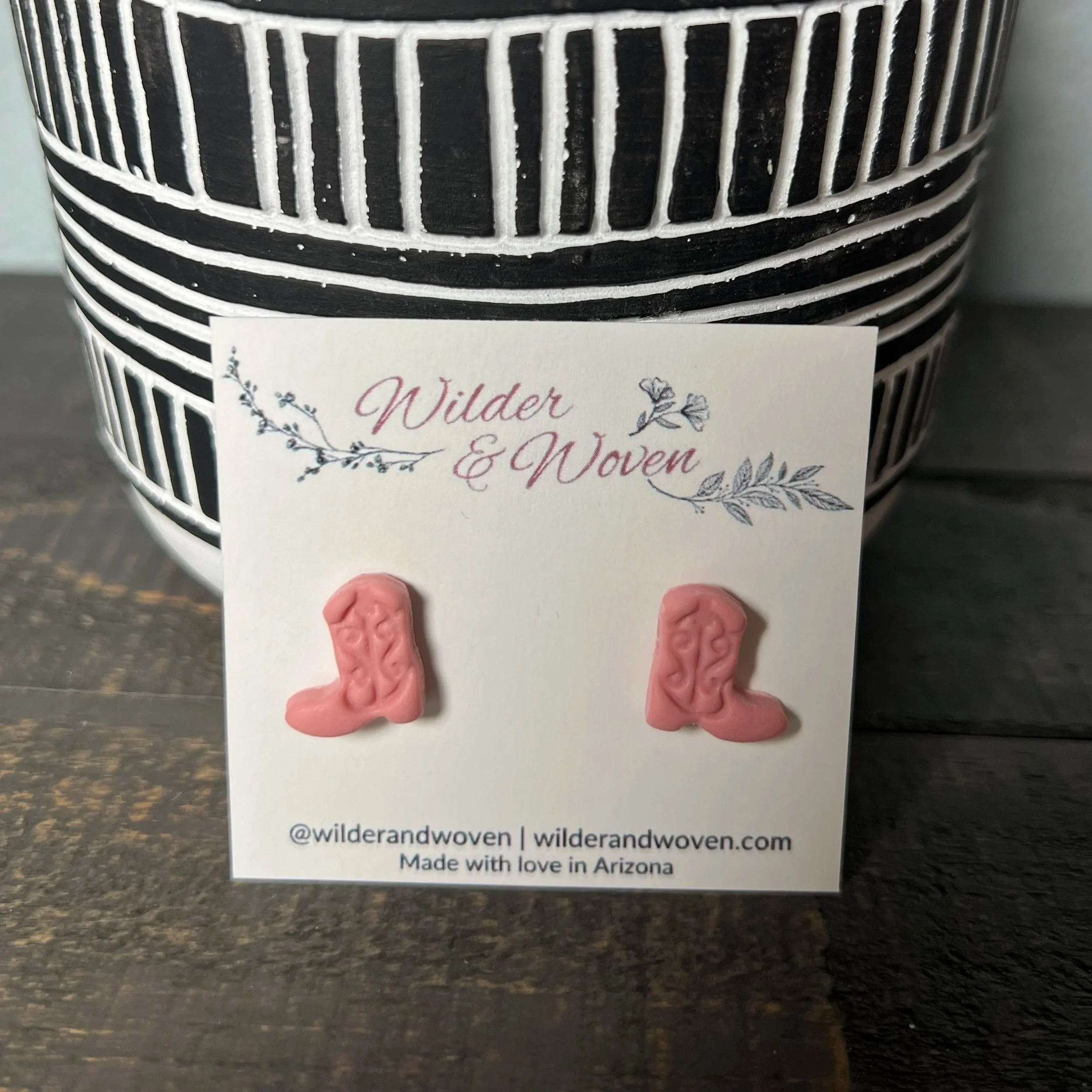 Handcrafted polymer clay cowgirl boot stud earrings in a blush pink tone, displayed on a Wilder & Woven branded jewelry card.