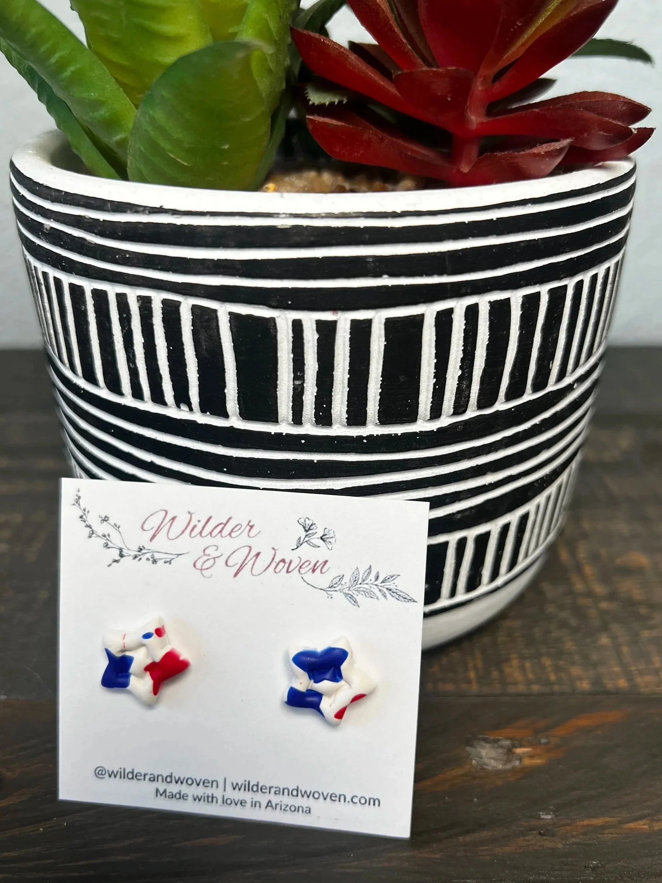 Handmade red, white, and blue marbled polymer clay star stud earrings displayed on a Wilder & Woven earring card.