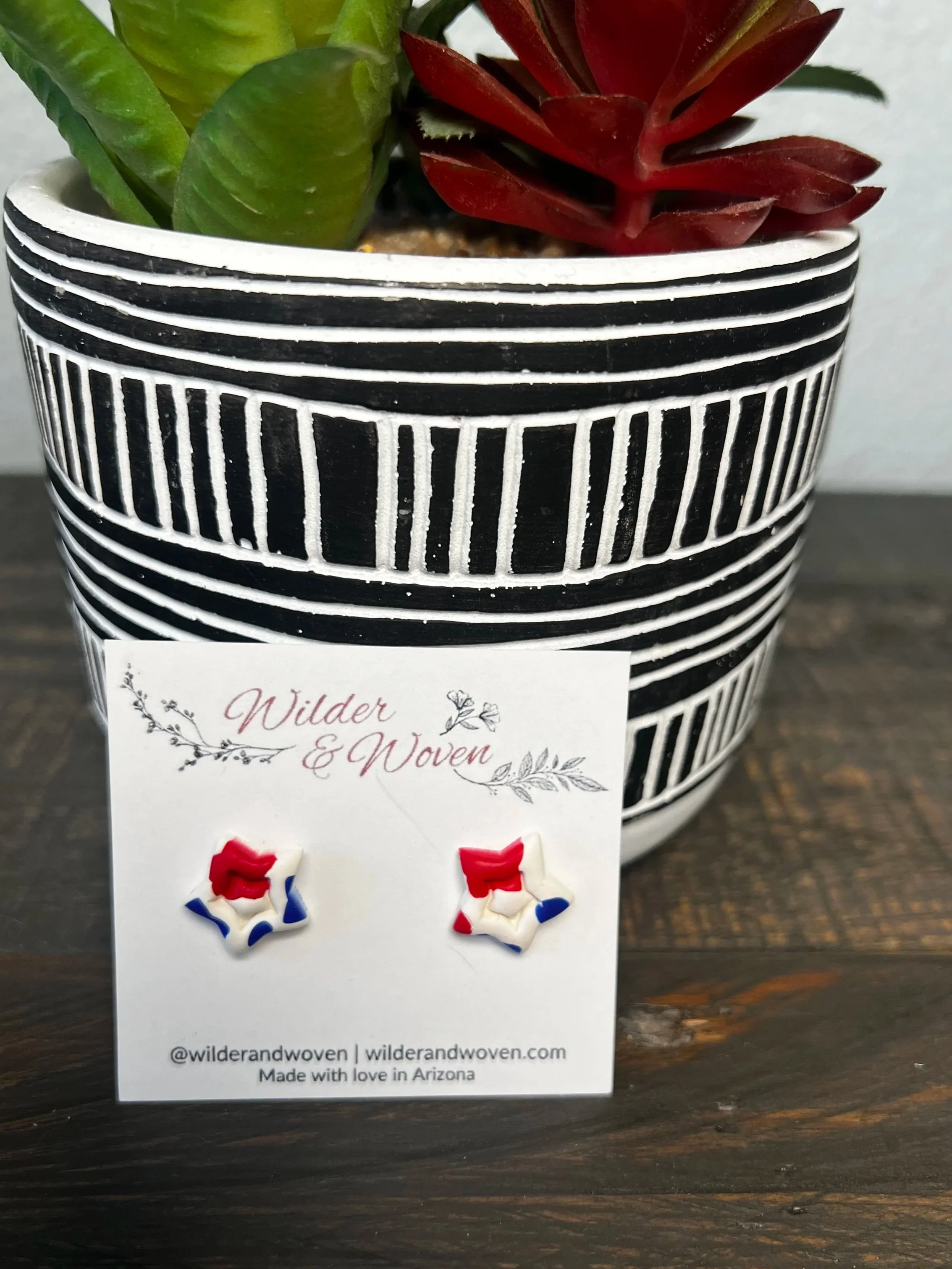 Handmade red, white, and blue marbled polymer clay star stud earrings displayed on a Wilder & Woven earring card.