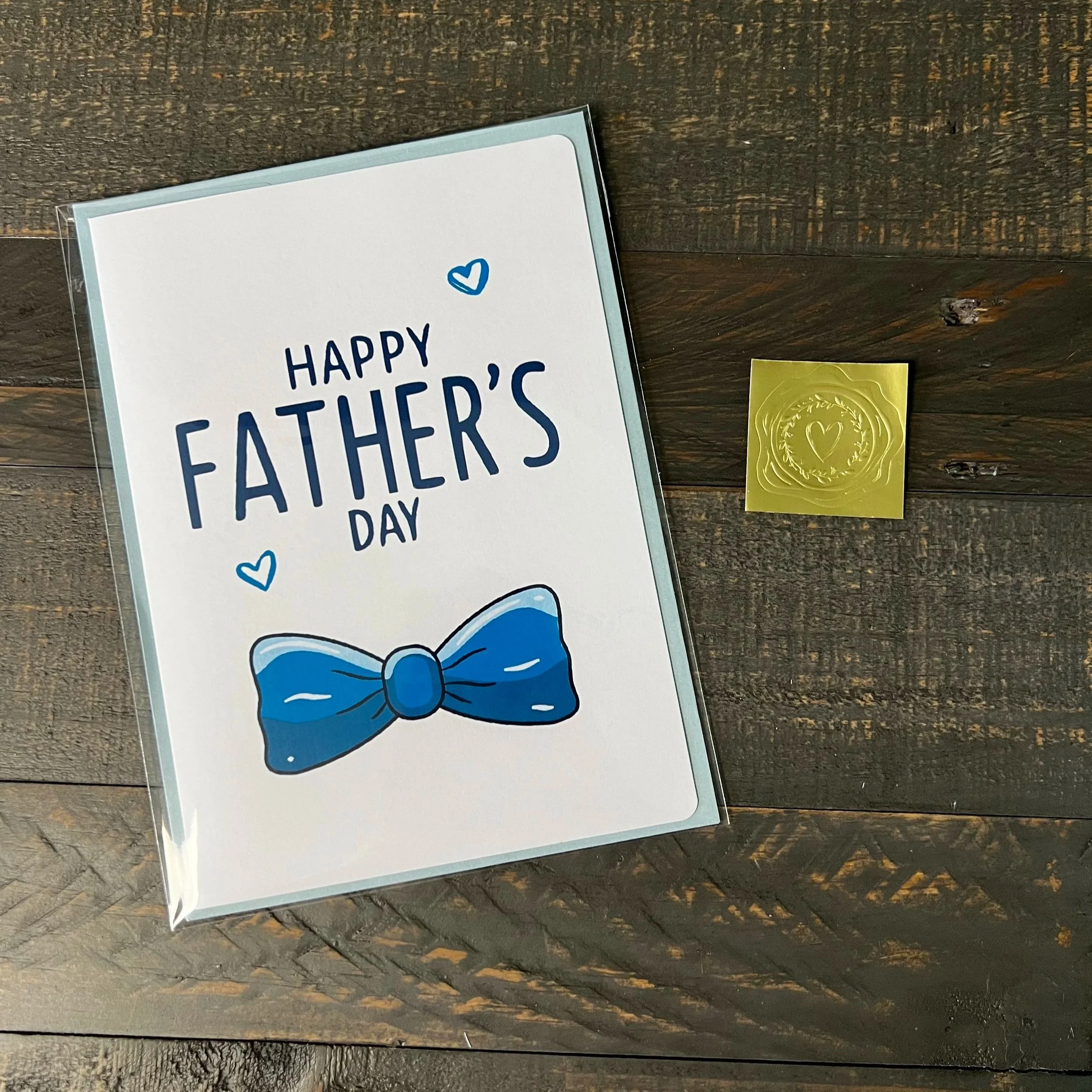 Blue bow tie Father’s Day card with coordinating light blue envelope and gold wax seal sticker
