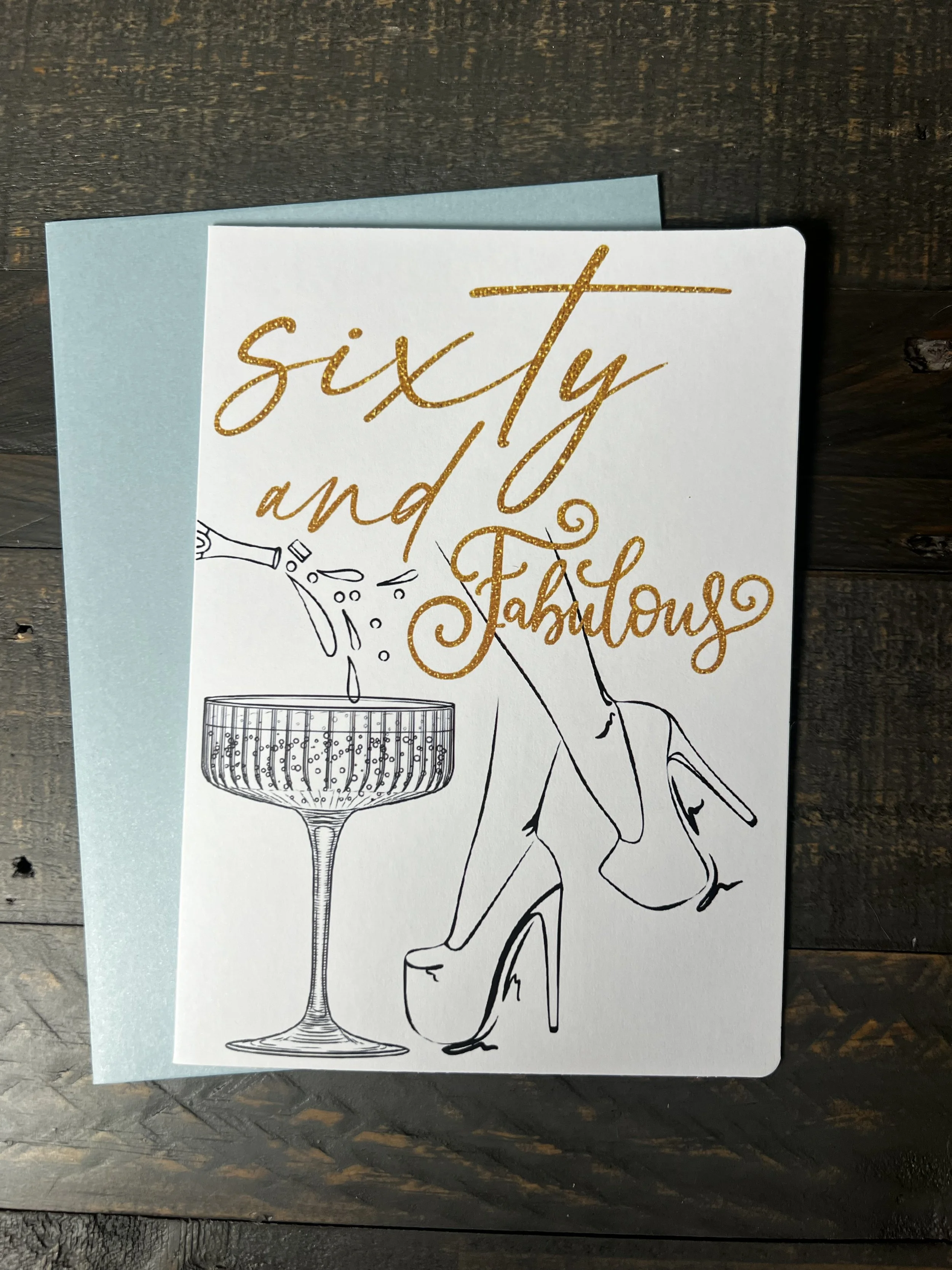 Front of Sixty & Fabulous greeting card with coordinating soft blue envelope.