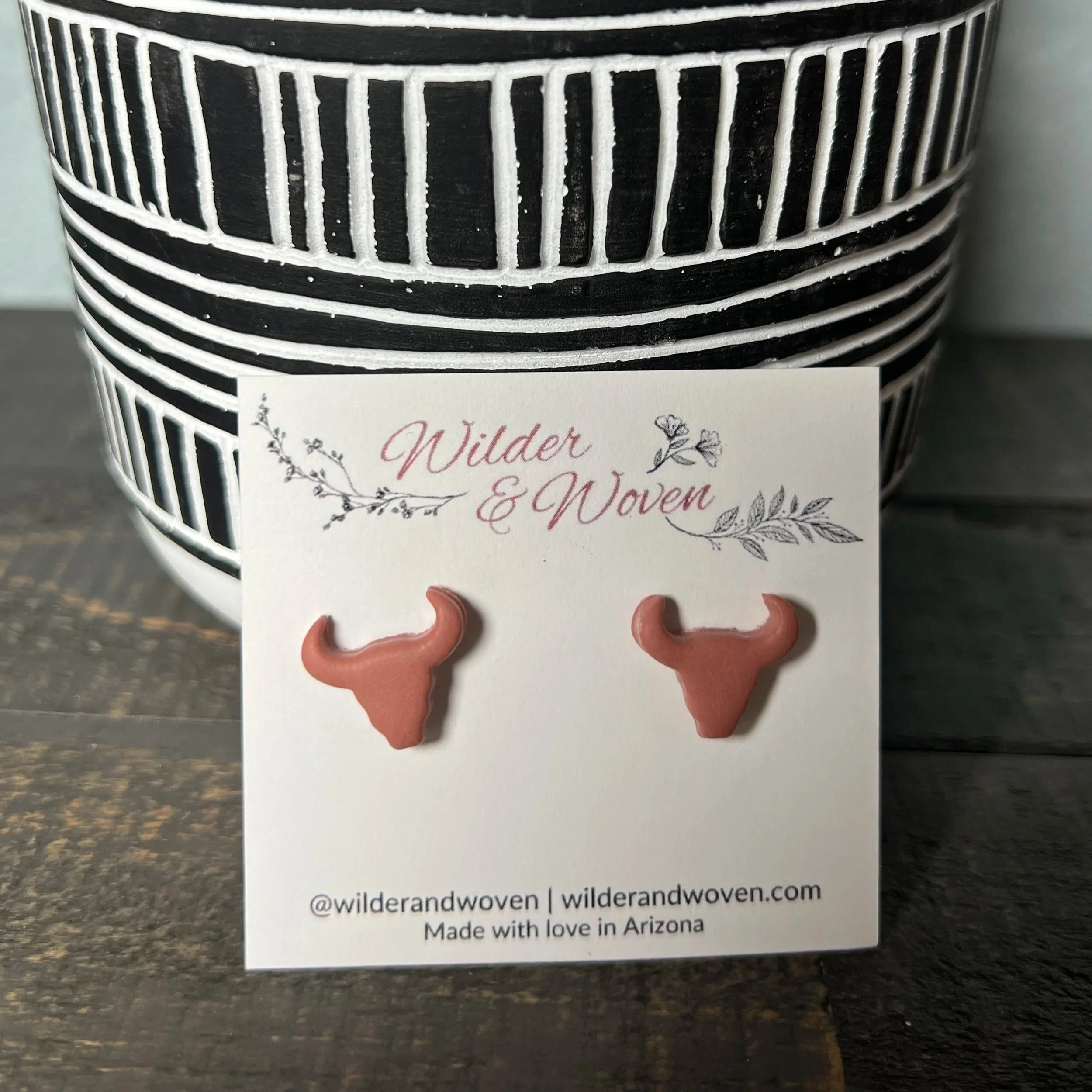 Handcrafted polymer clay longhorn stud earrings in a warm Sedona clay tone, displayed on a Wilder & Woven branded jewelry card.