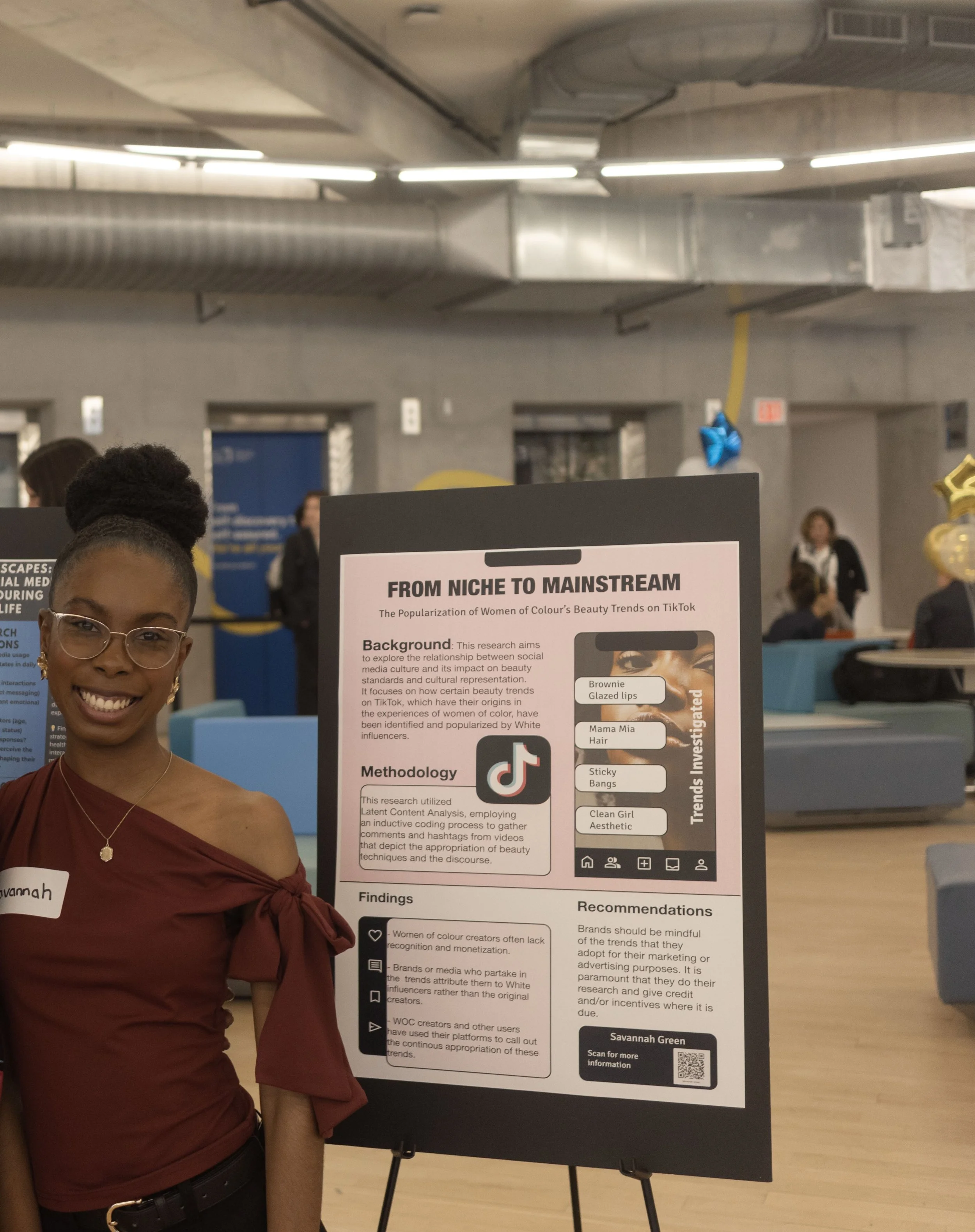 Savannah Green in front of her poster at Signify 2025